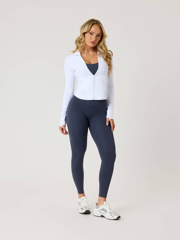 Front view of a woman wearing the slim-fit Alice Stenlöf Soft Zip Midlayer in Brilliant White (White) for training. - Image 3