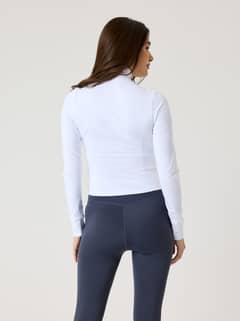 Back view of a model wearing the slim-fit Alice Stenlöf Soft Zip Midlayer in Brilliant White (White) for training. - Image 9