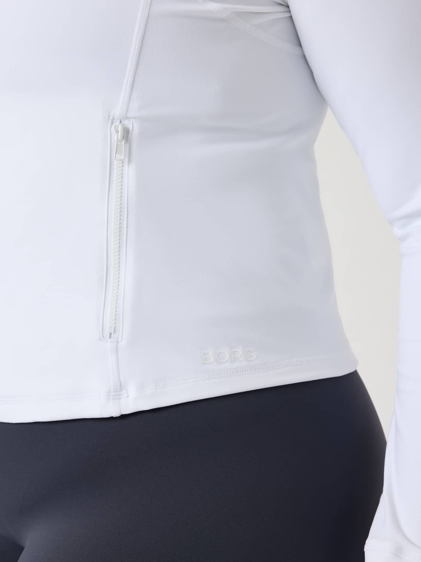 The slim-fit Alice Stenlöf Soft Zip Midlayer in Brilliant White (White) for training, featuring a tonal hip logo. - Image 15