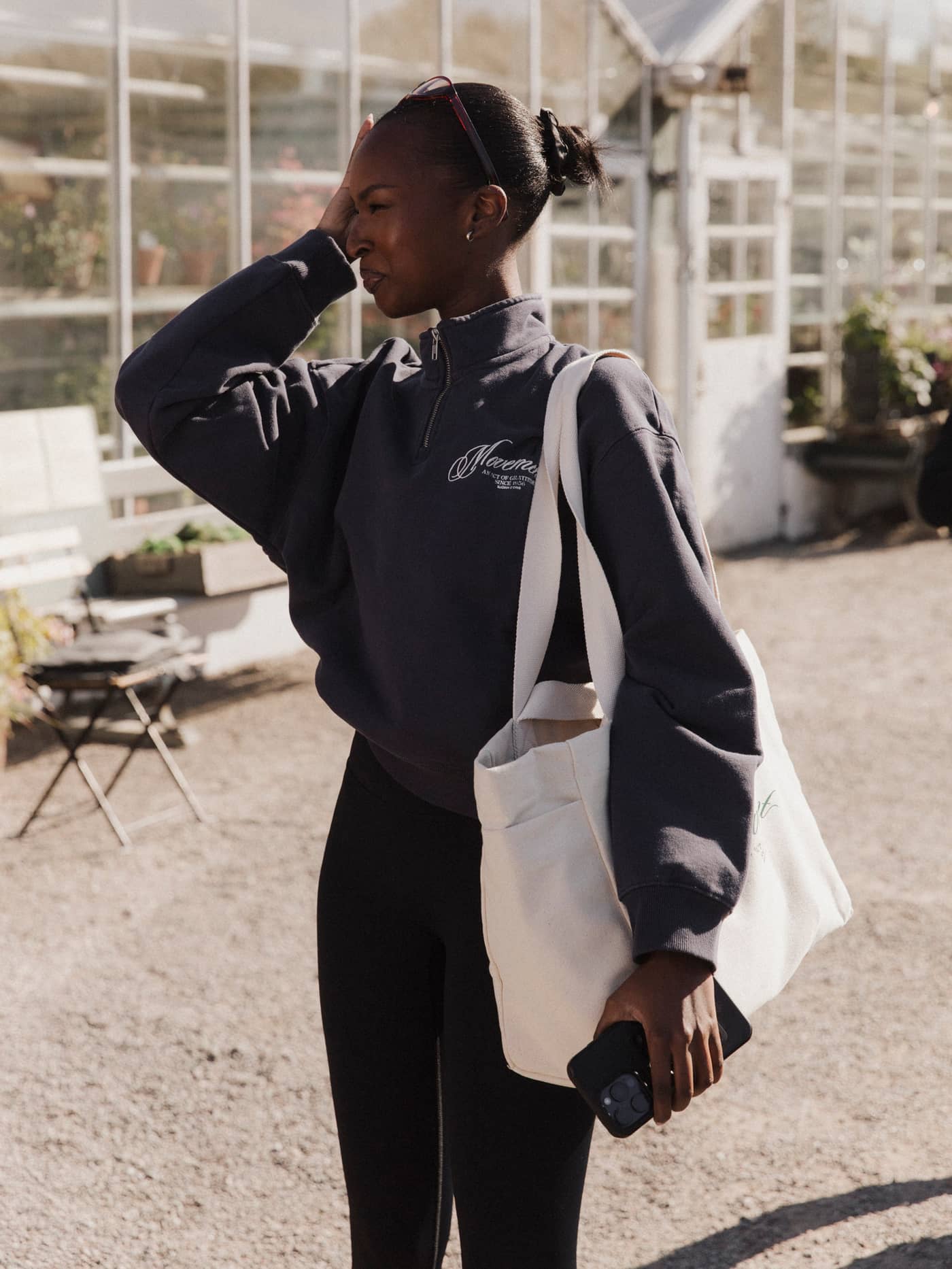 Side view of a woman carrying the Alice Stenlöf Canvas Tote 24L in Egret (White), made from durable cotton canvas. - Image 4