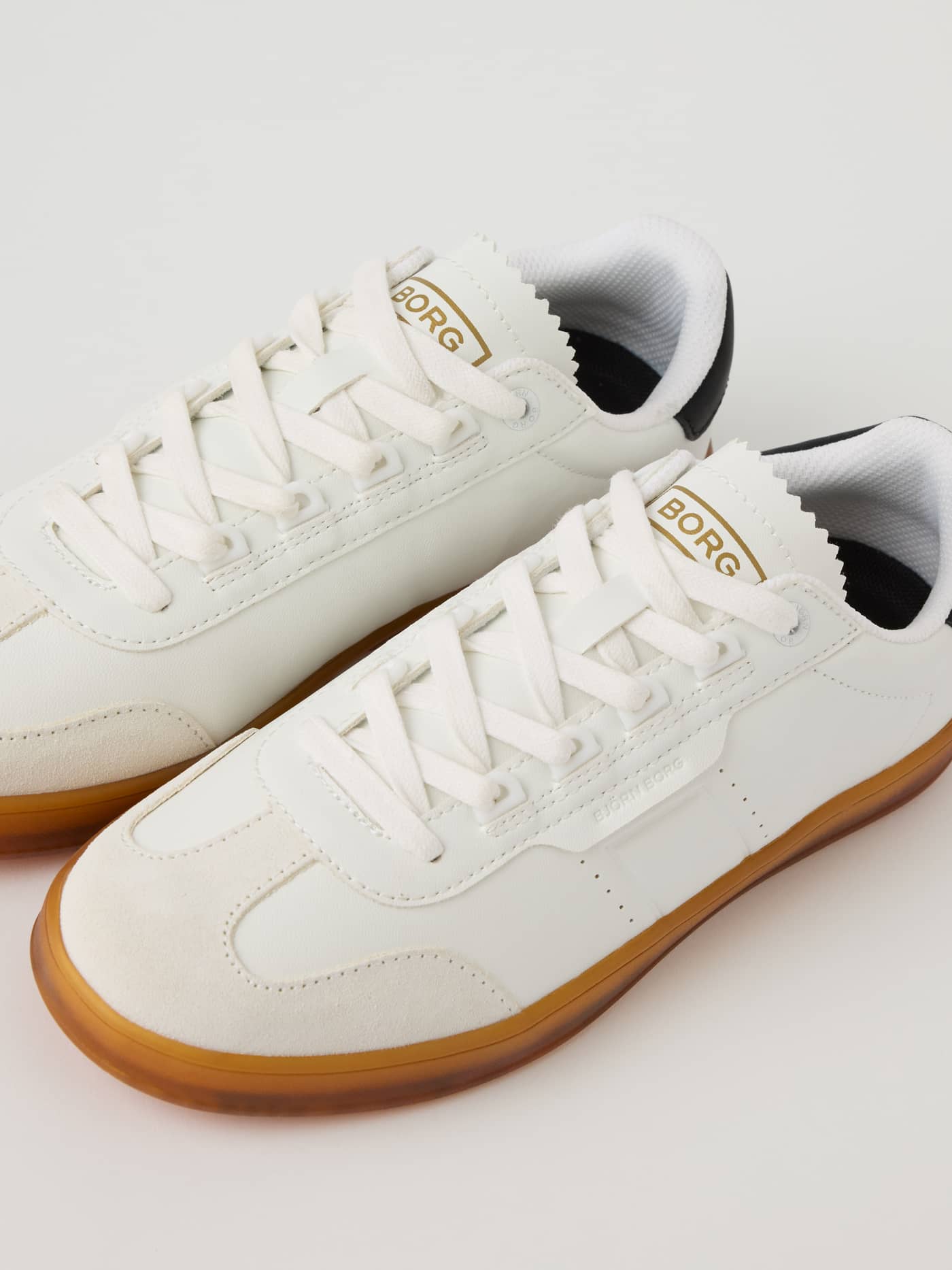 Angled view of the white Women’s Sneakers T2500 in synthetic leather and suede with a gold logo and tennis style. - Image 3