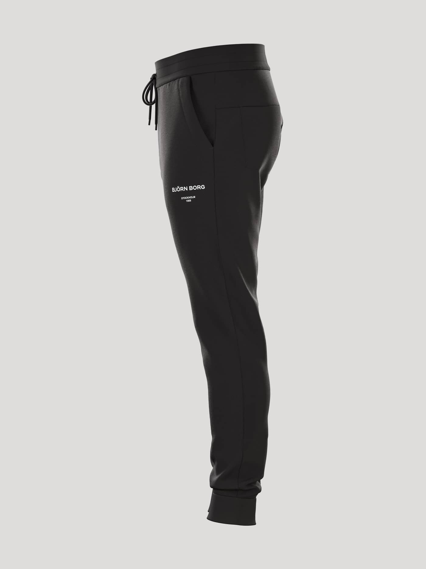 Vista lateral de Borg Essential 1 Sweatpants en Black Beauty (Negro) con pernera entallada y logo blanco para tiempo libre. - Image 4