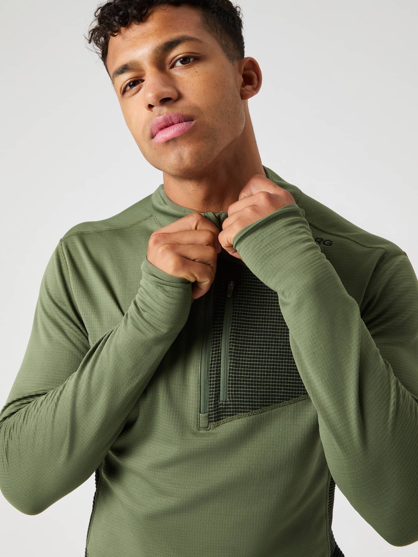 Gros plan d'un homme portant le Borg Fleece Midlayer en Forest Night (Vert), alliant style et fonction pour l'entraînement. - Image 6
