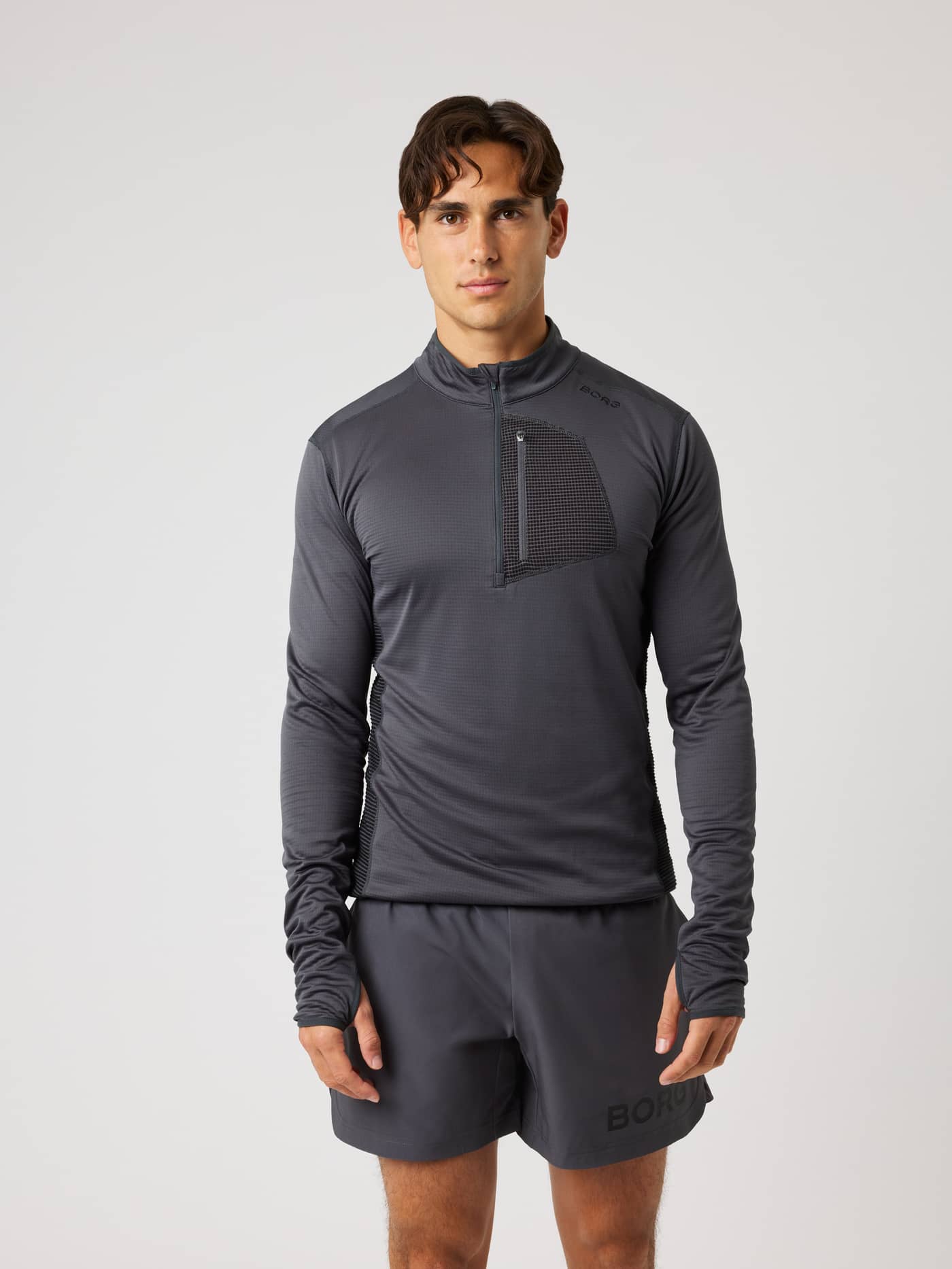 Front view of a man wearing the Borg Fleece Midlayer in Asphalt (Black), a waffle fleece training top with a black logo. - Image 2