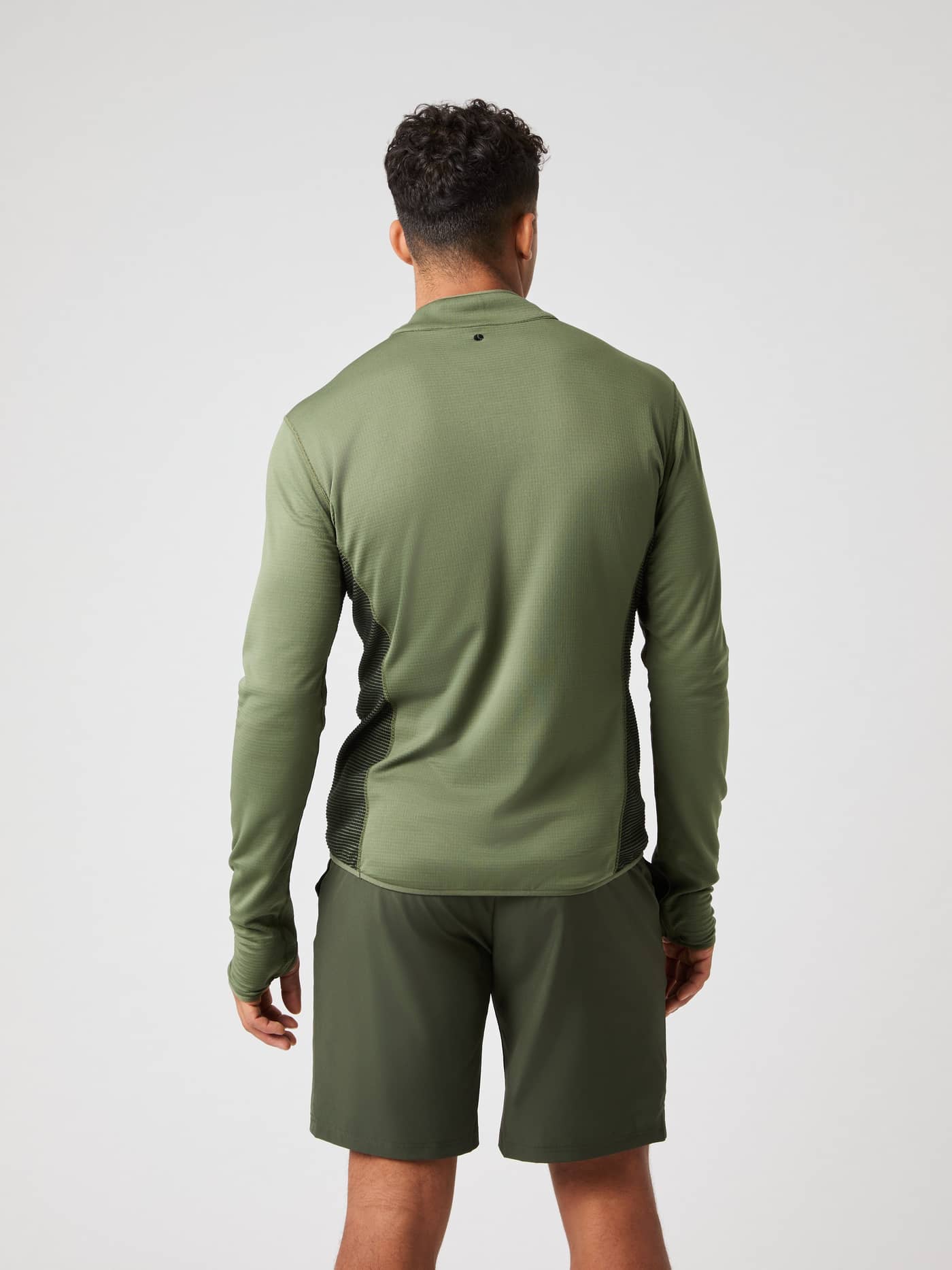 Vue de dos d'un homme portant le Borg Fleece Midlayer Forest Night (Vert) avec logo noir, idéal pour l'entraînement. - Image 2
