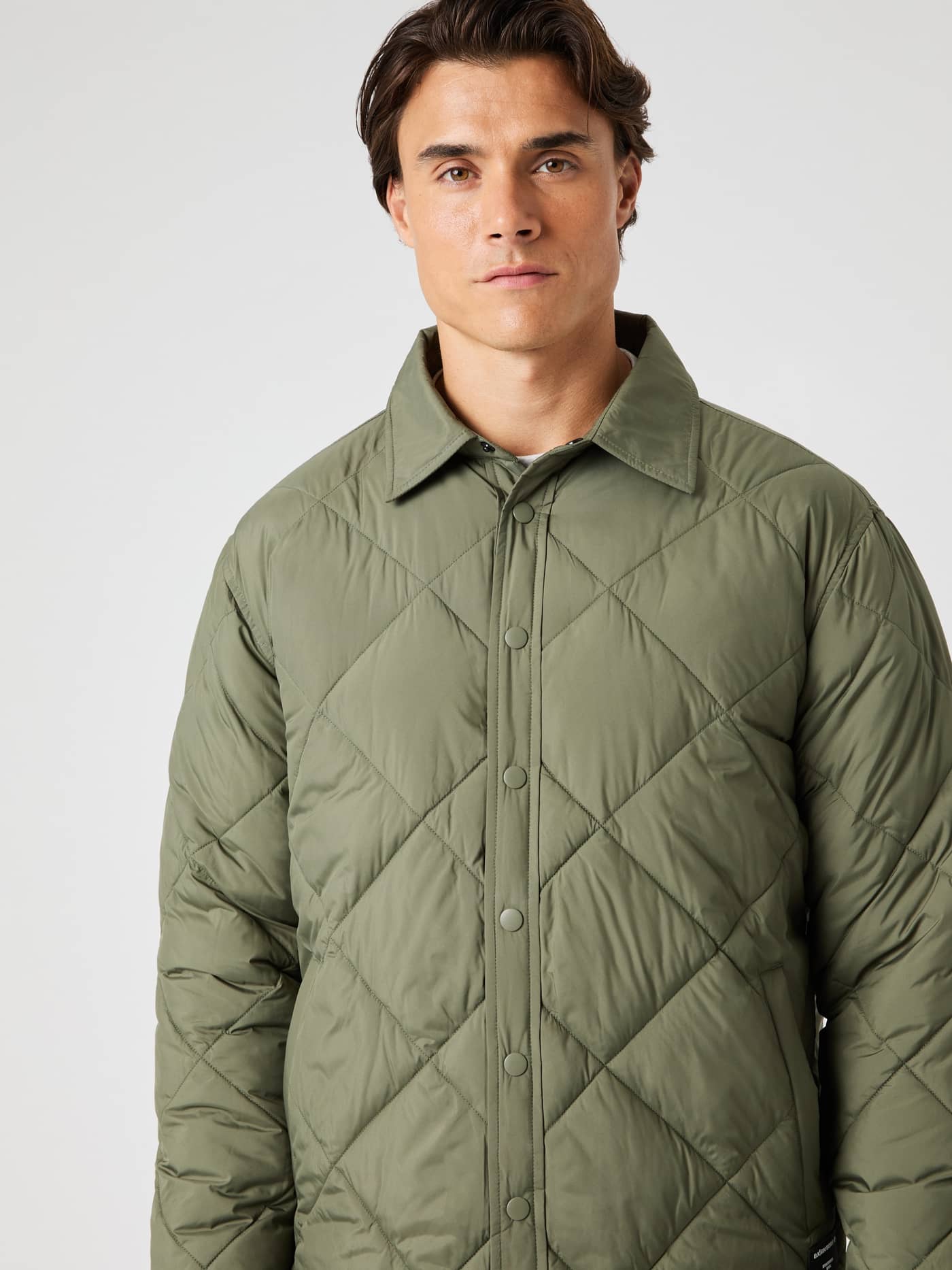 Vorderansicht eines Mannes im Centre Quilted Overshirt in Dusty Olive (Grün) mit funktionalem Steppdesign. - Image 5