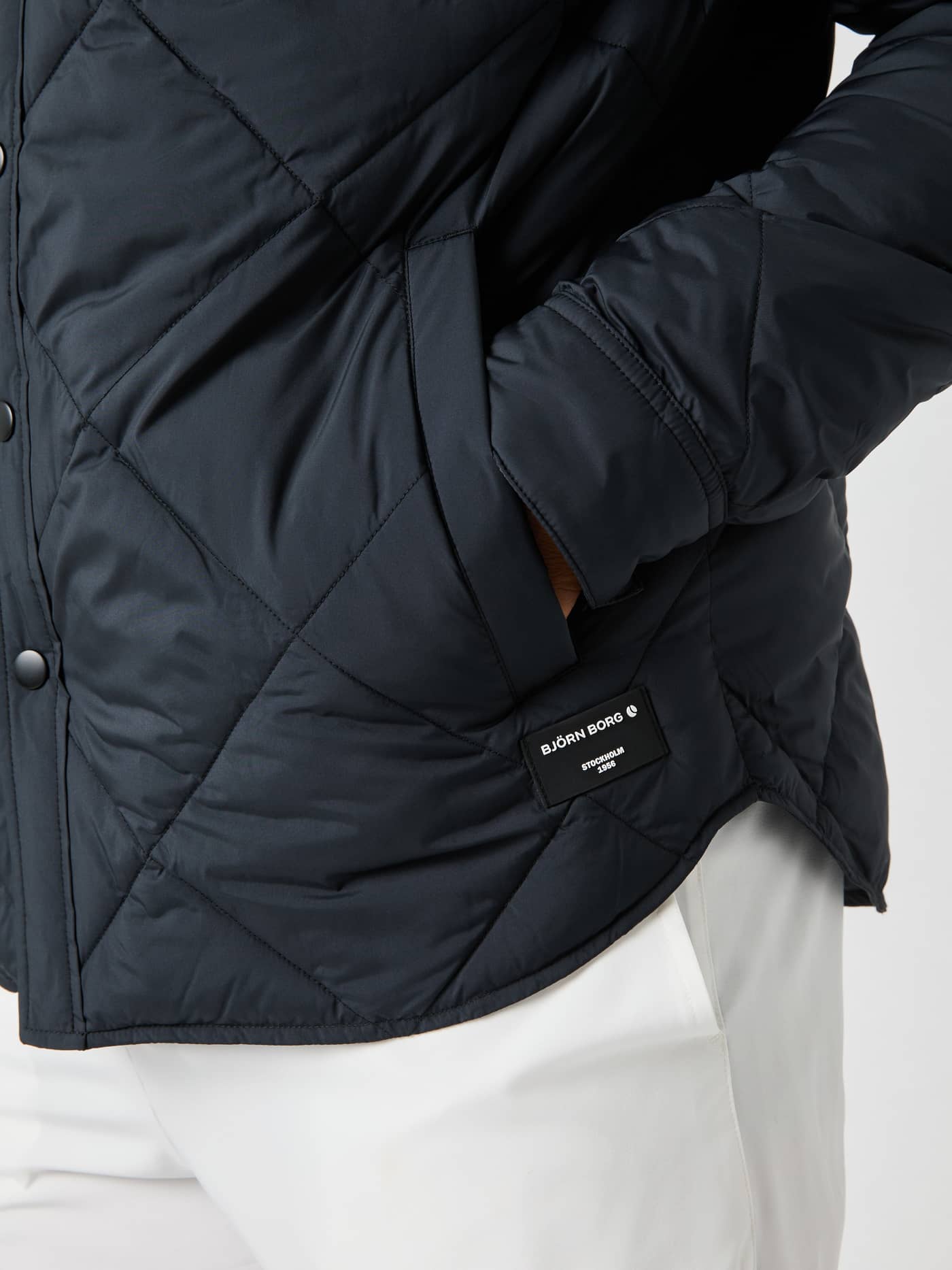 Nahaufnahme des Centre Quilted Overshirt in Black Beauty (Schwarz) mit gesteppter Textur und schwarzem Logo-Patch. - Image 5