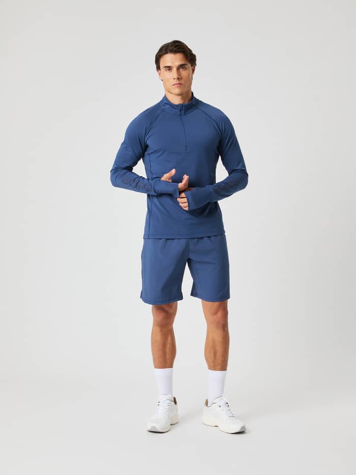 Full-body front view of a man in Sargasso Sea (Blue) Borg Athletic 9 Inch Shorts, built for performance and training.