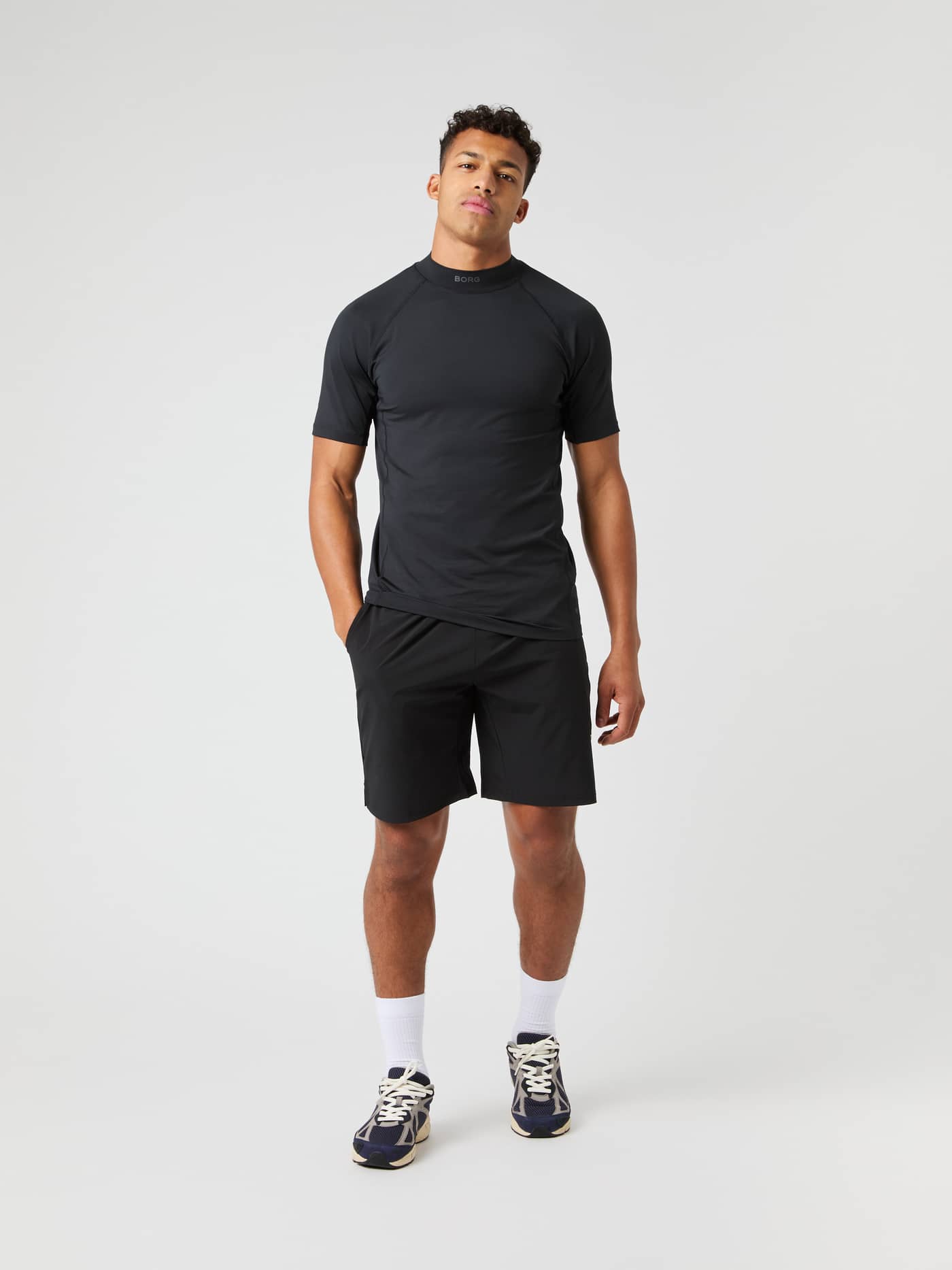 Full-body front view of a man wearing Black Beauty (Black) Borg Athletic 9 Inch Shorts with a white logo for gym training. - Image 1