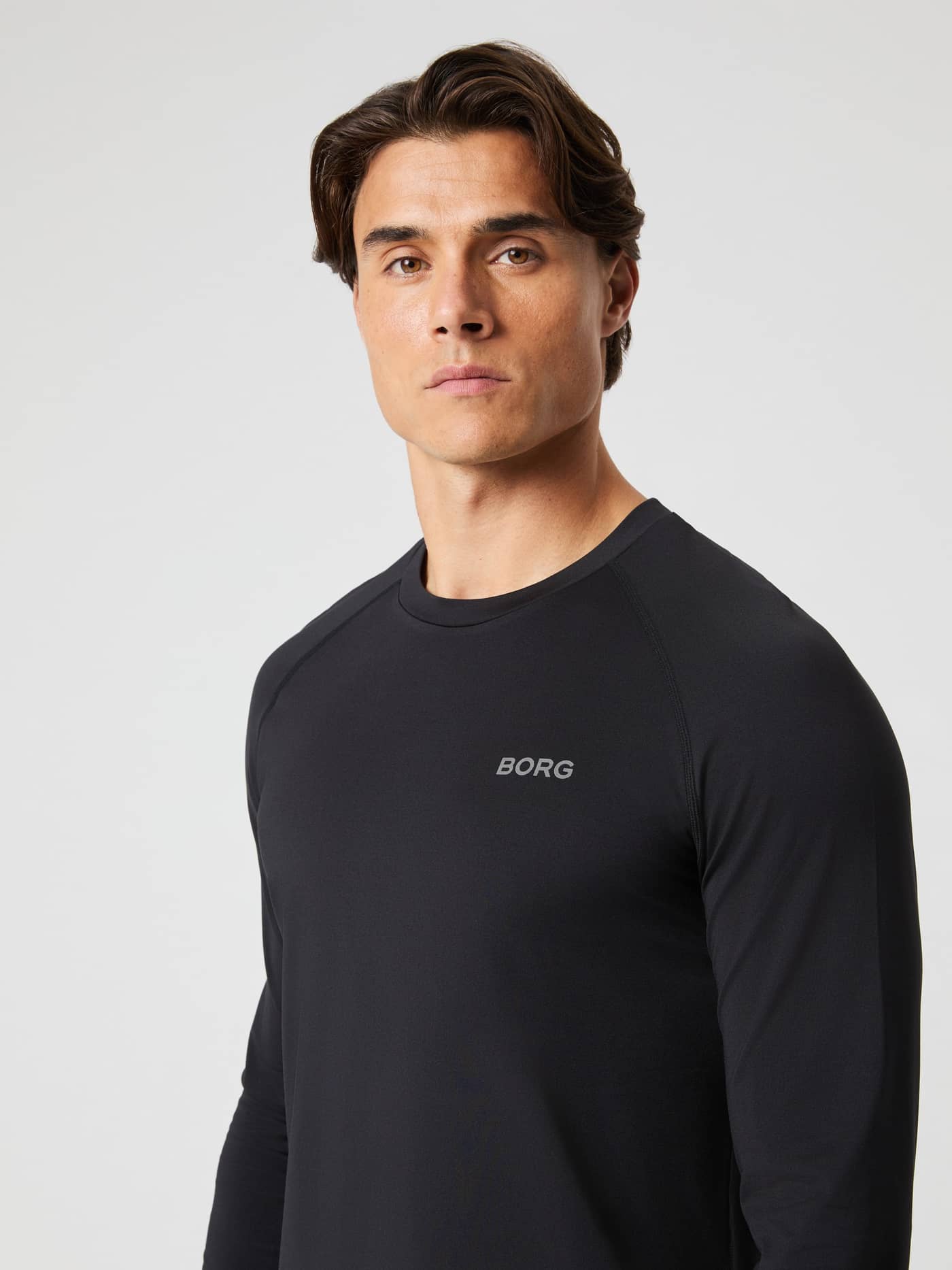 Front view of a man in the running Borg Performance Long Sleeve Brushed T-Shirt in Black Beauty (Black) with a grey logo. - Image 5