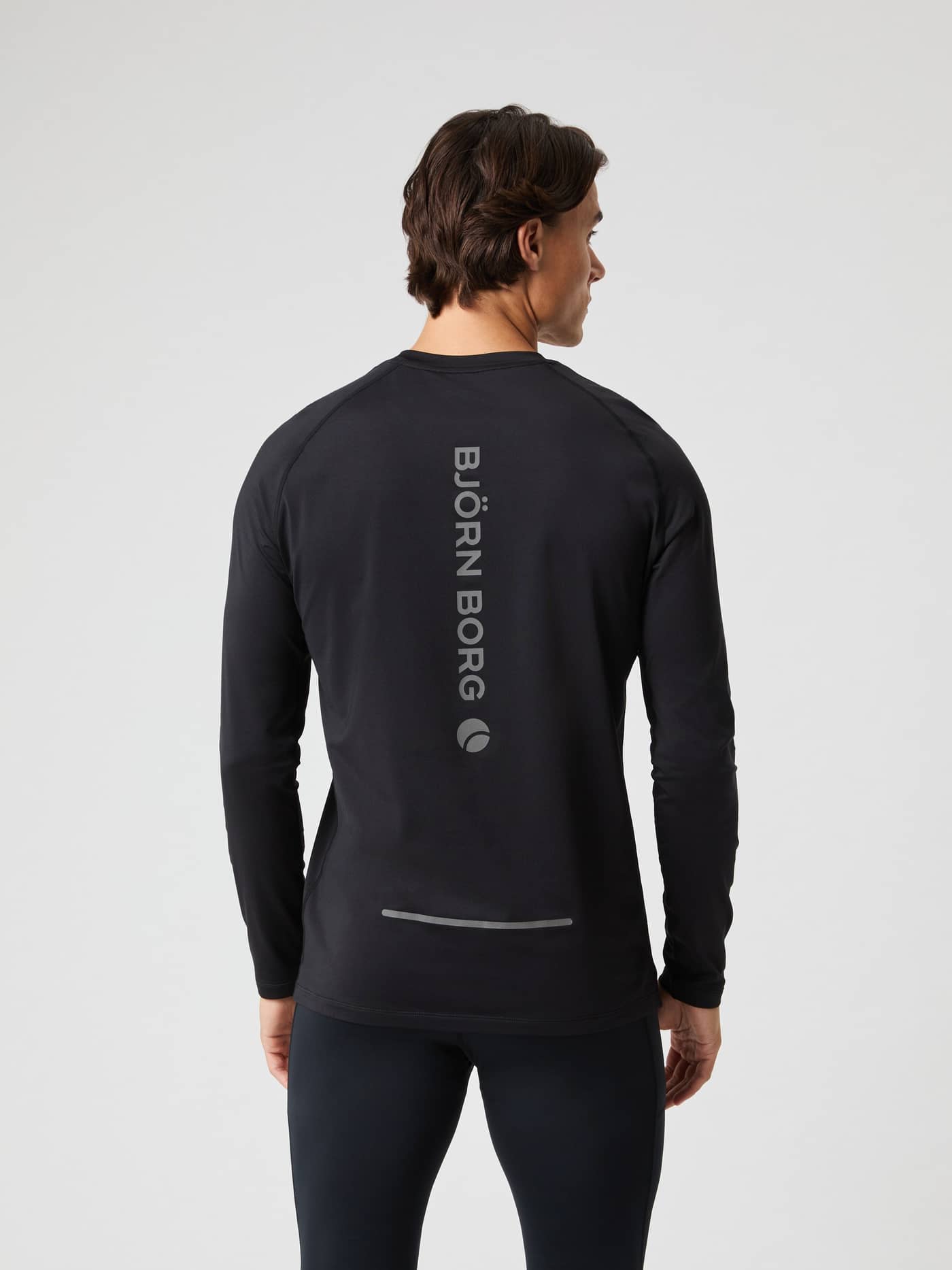 Back view of a man wearing the running Borg Performance Long Sleeve Brushed T-Shirt in Black Beauty (Black) with grey logo. - Image 2