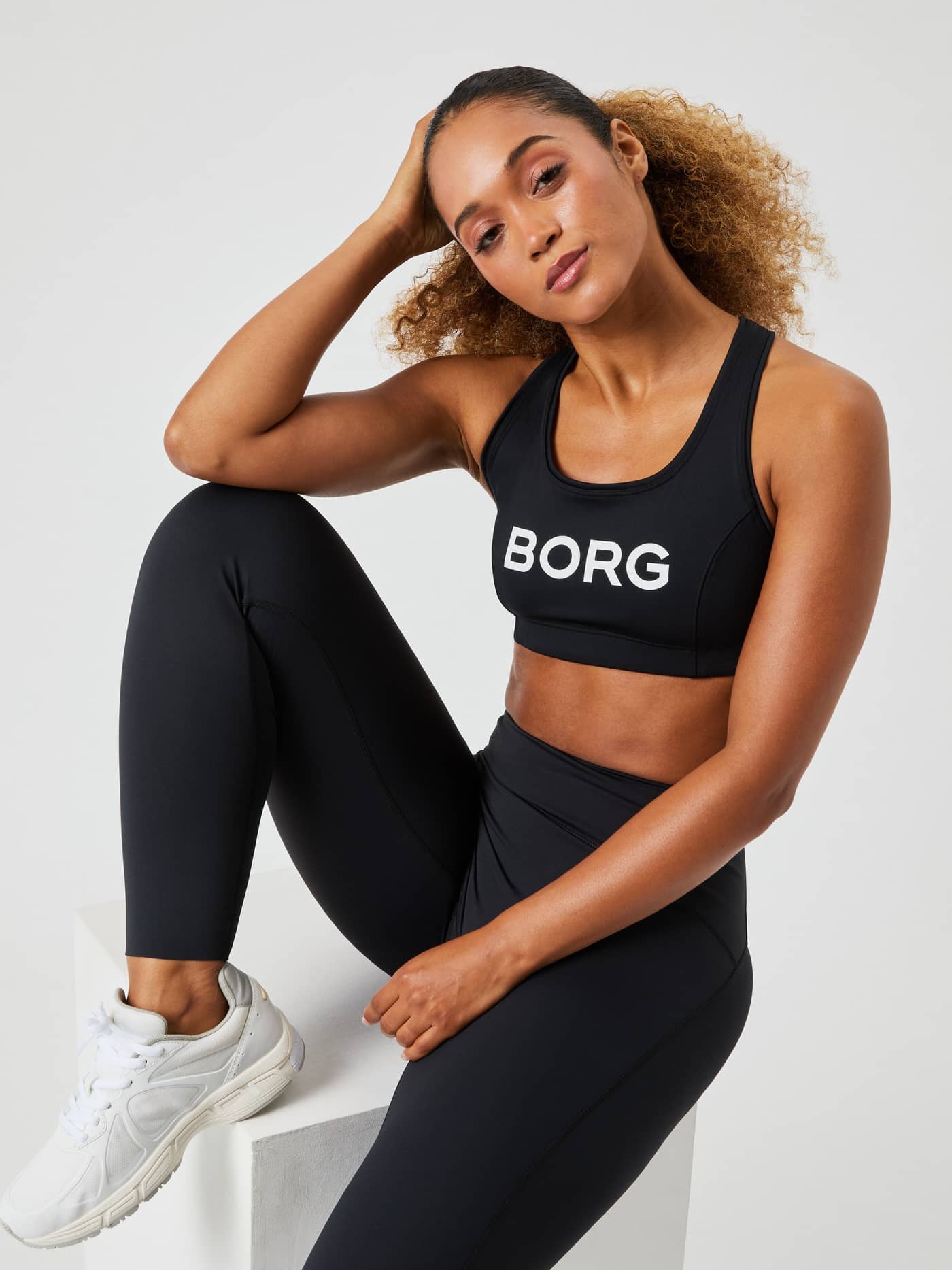 Borg Mid Support Sports Bra i Black Beauty (Sort) med hvidt logo og en stilfuld pasform til træning. - Image 1