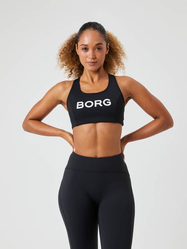 Borg Mid Support Sports Bra i svart sedd framifrån med vit logotyp, en sport-bh med snygg passform för träning.