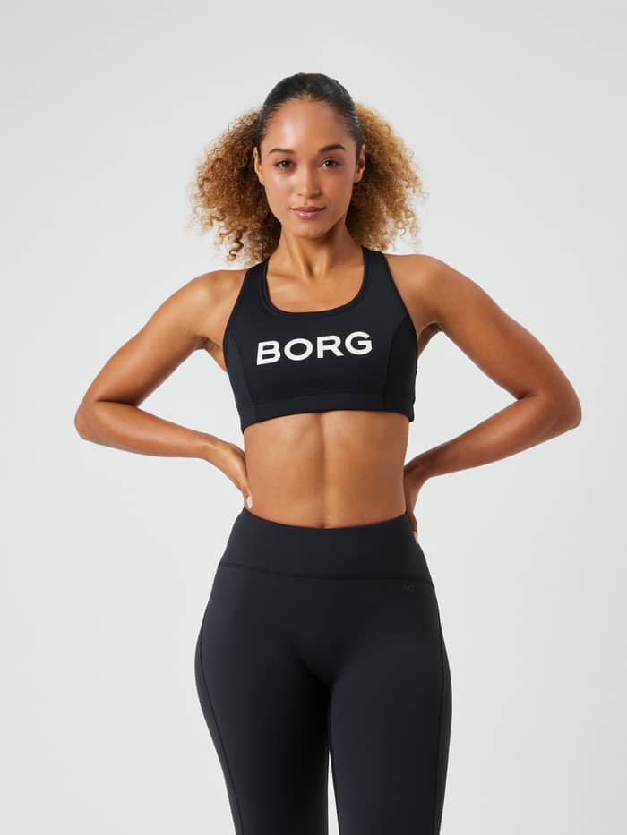 Vorderansicht: Borg Mid Support Sports Bra in Black Beauty (Schwarz) mit weißem Logo, stilvoller Fit für das Training.