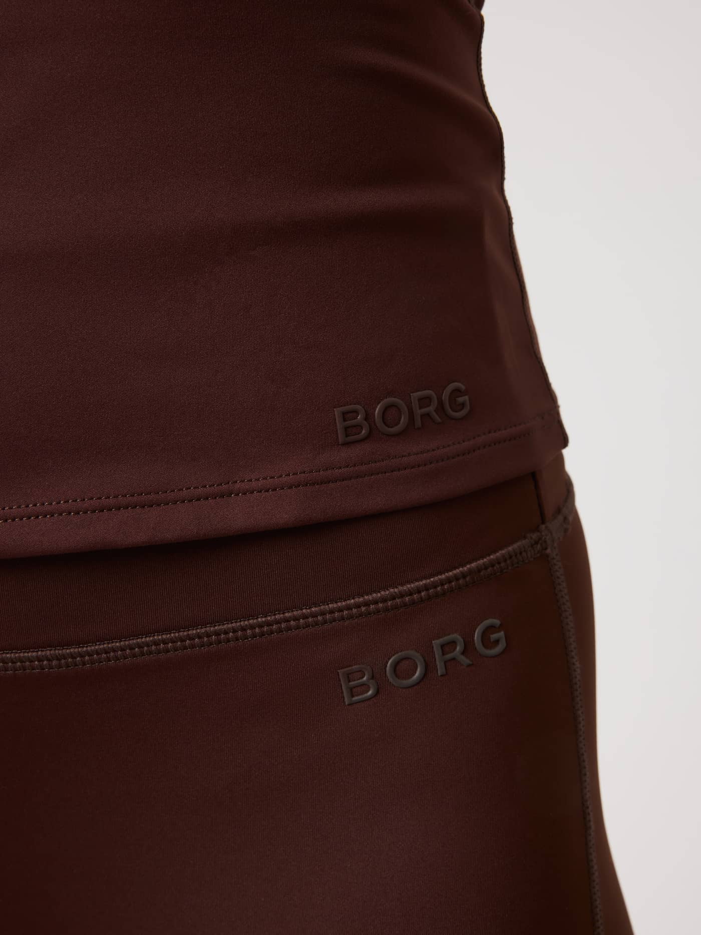 Close-up of the Borg Soft Racerback Tank Top in Coffee Bean (Brown) with a tonal logo, designed for training. - Image 4