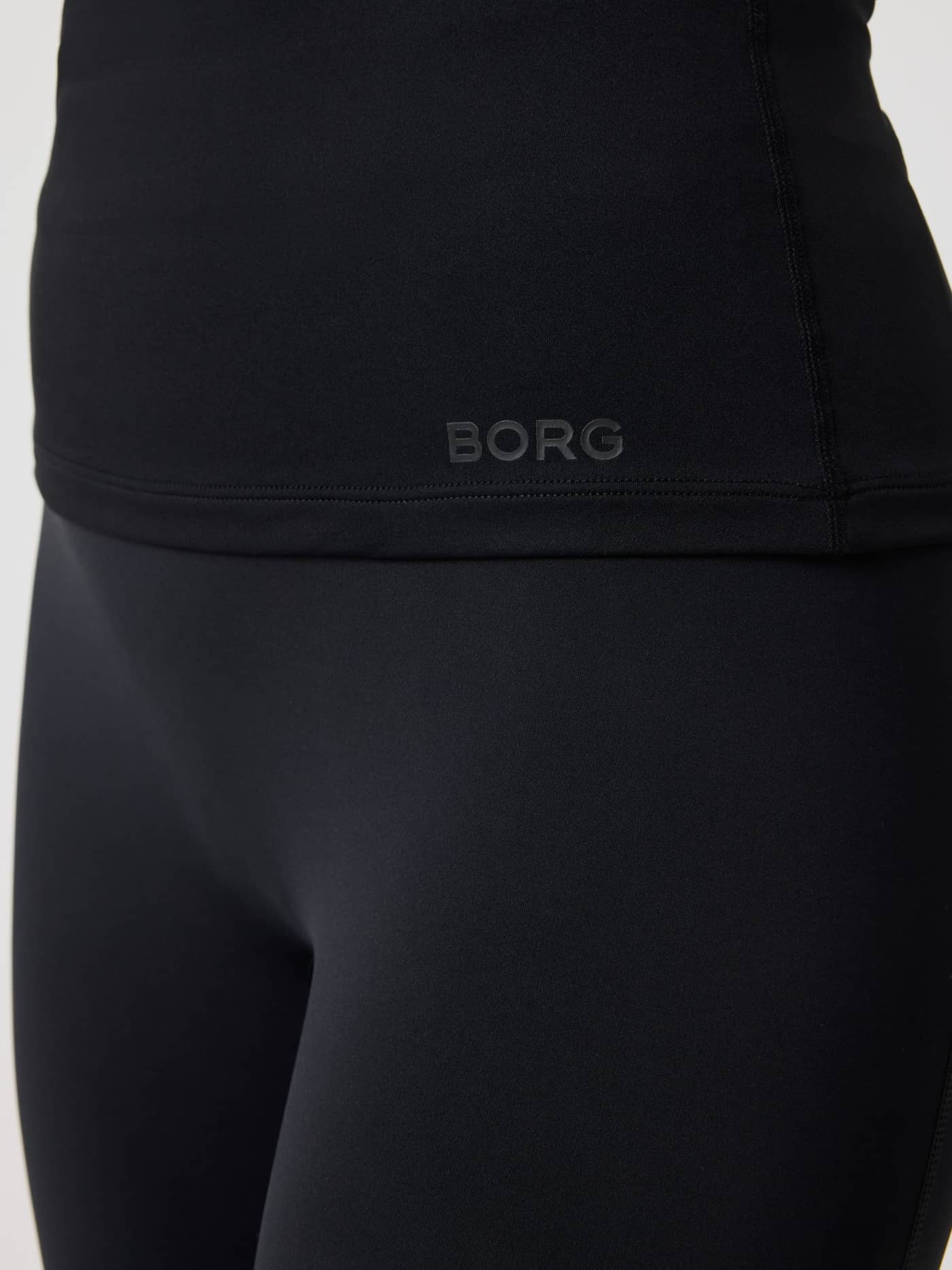 Detailed close-up of the black logo on the training-ready Borg Soft Racerback Tank Top in Black Beauty (Black). - Image 5