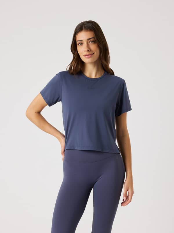 Front view of a woman wearing the Odyssey Gray (Navy) Borg Cropped T-Shirt, a stylish training top with a flattering fit.