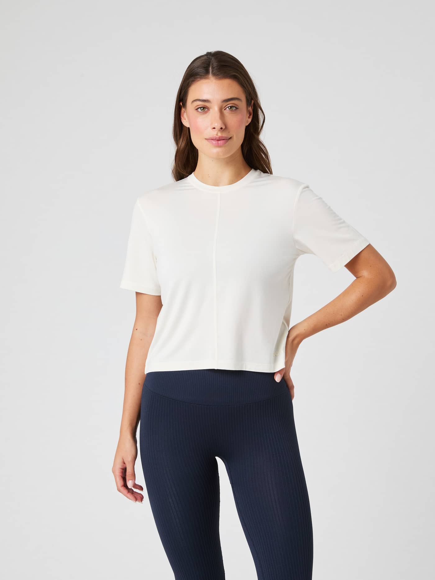 Front view of a woman wearing the Björn Borg Studio Soft T-Shirt in Tofu (White), a cropped modal training top. - Image 3