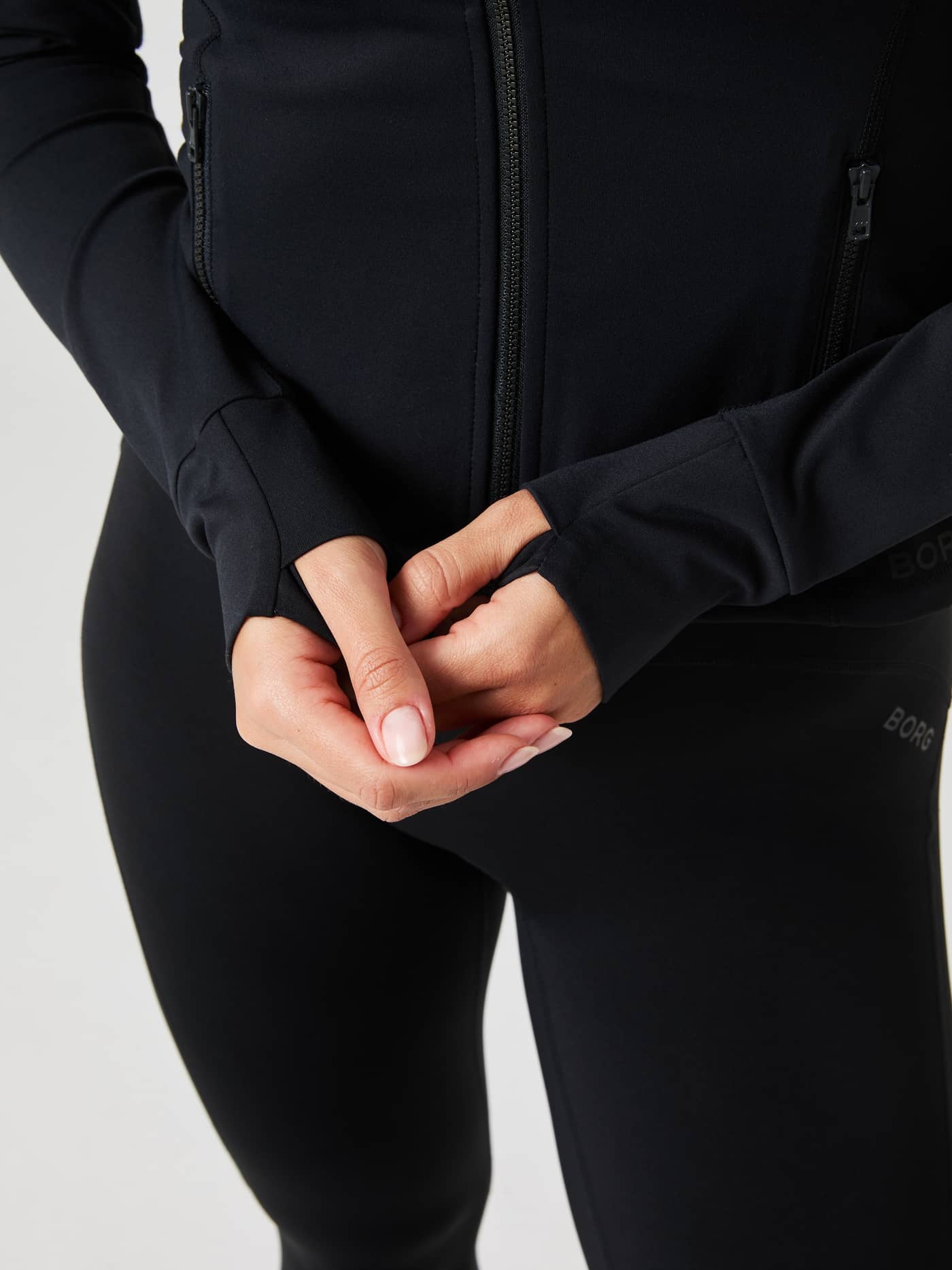 Gros plan détaillé du Borg Soft Zip Midlayer en Black Beauty (Noir) avec passe-pouces et logo noir pour l'entraînement. - Image 7