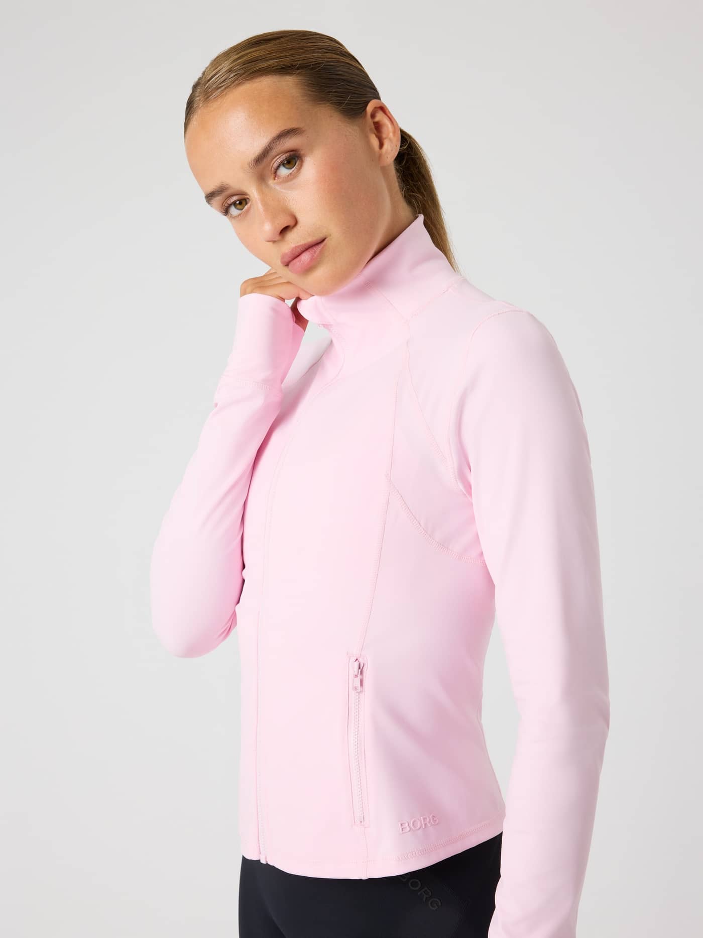 Side view of a woman wearing the Borg Soft Zip Midlayer in Pink Lady (Pink) with a tonal logo for training style and fit. - Image 8