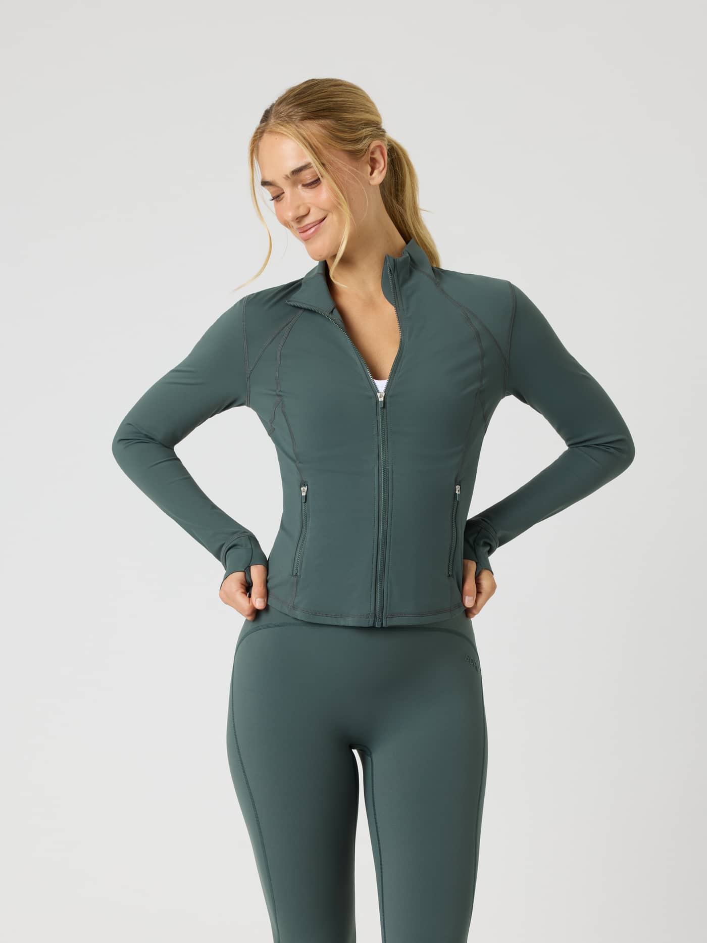 Vista frontal de una mujer con Borg Soft Zip Midlayer en Urban Chic (Verde) de cuello alto para entrenamiento entallado. - Image 1