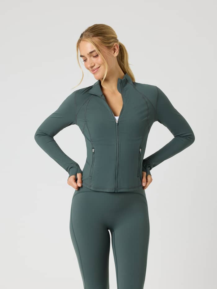 Modell framifrån i Borg Soft Zip Midlayer i Urban Chic (Grön) med mock neck och slim fit för träning.