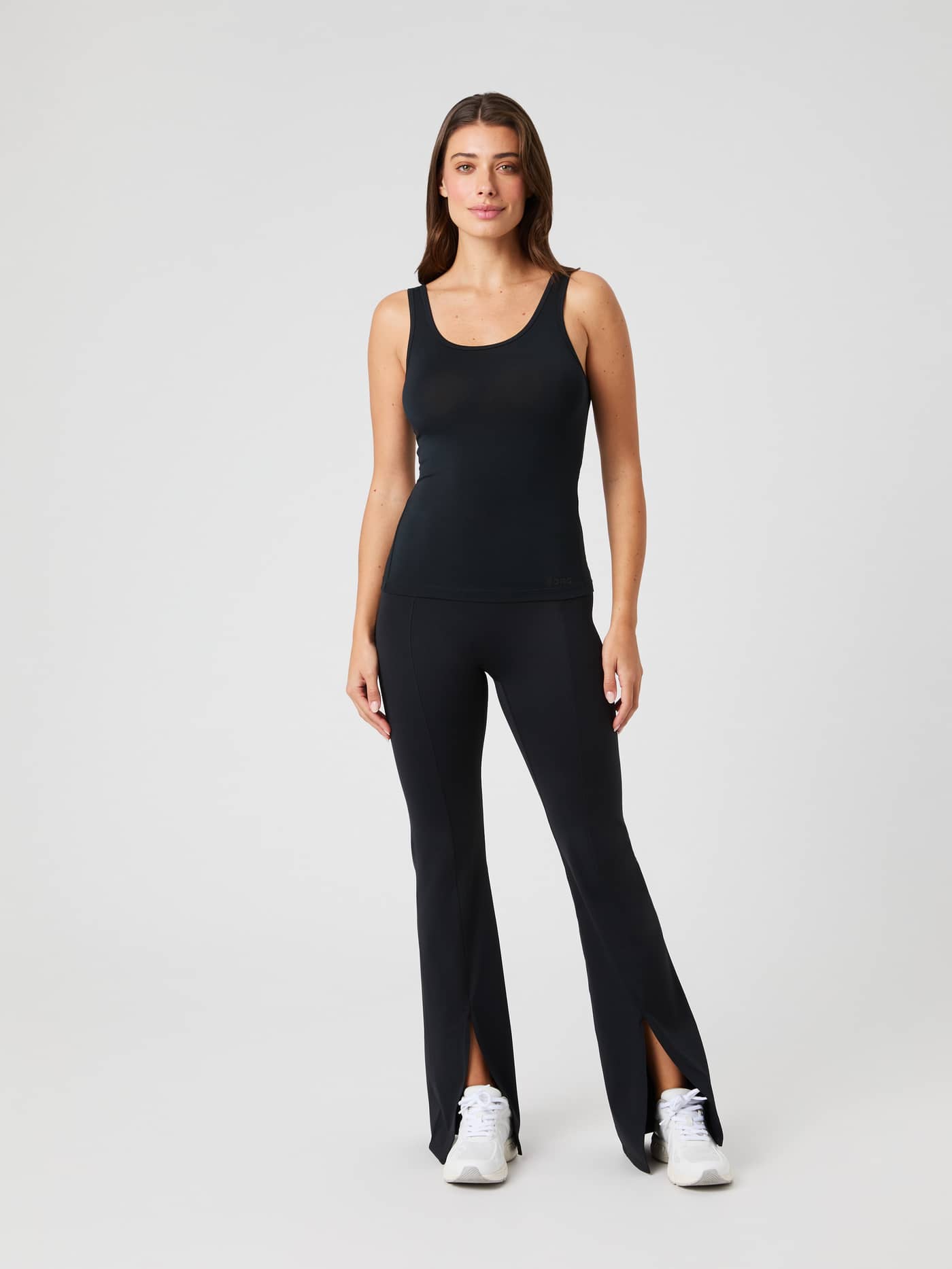 Full-body front view of a model wearing the fitted Studio Deep Back Tank Top in Black Beauty (Black) for training. - Image 3
