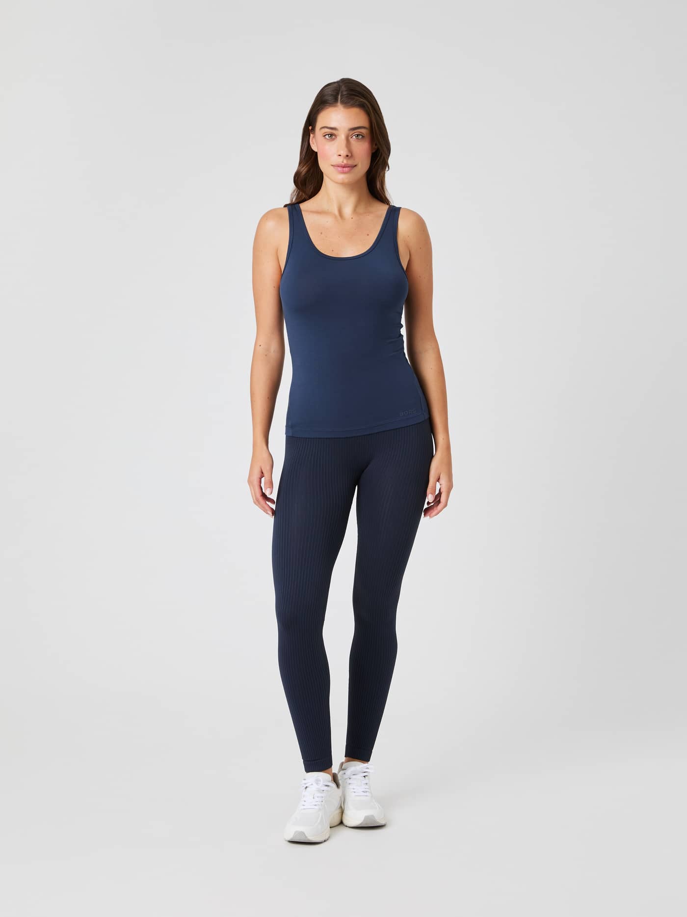 Vue de face d'une femme portant le Studio Deep Back Tank Top d'entraînement Outerspace (Marine) avec une coupe ajustée. - Image 3