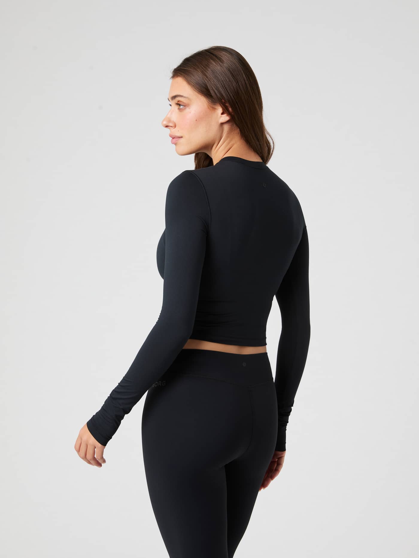 Studio Soft Cropped Longsleeve in Black Beauty (Zwart) met een strakke trainingspasvorm, getoond in achteraanzicht. - Image 3