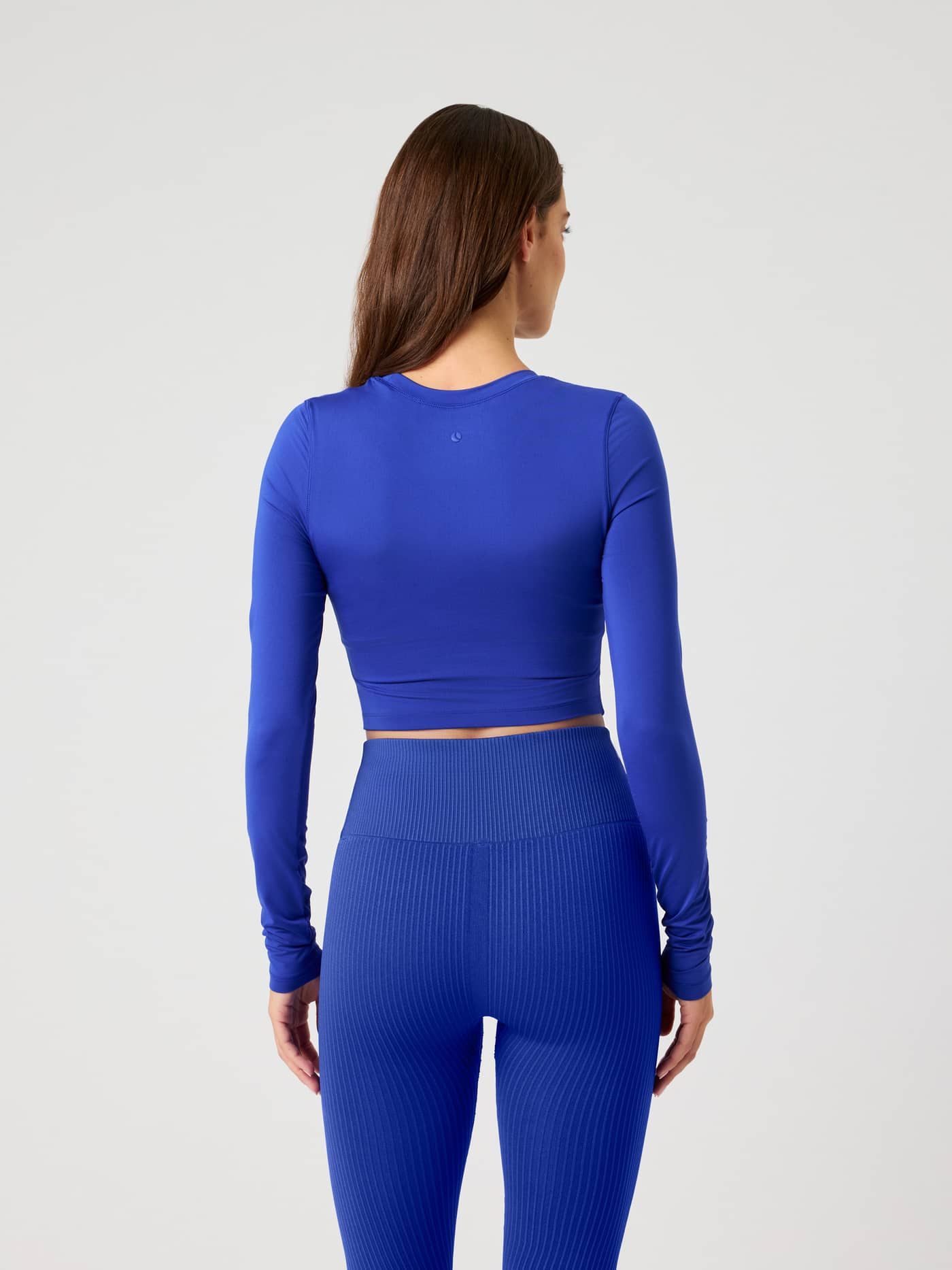 Studio Soft Cropped Longsleeve in Clematis Blue (Blauw) in achteraanzicht met een stijlvolle pasvorm voor training. - Image 3