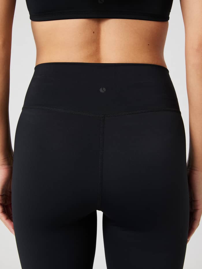 Rückansicht der Studio Flared Slit Tights in Black Beauty (Schwarz) mit tonalem Logo und stützender Passform fürs Training. - Image 5