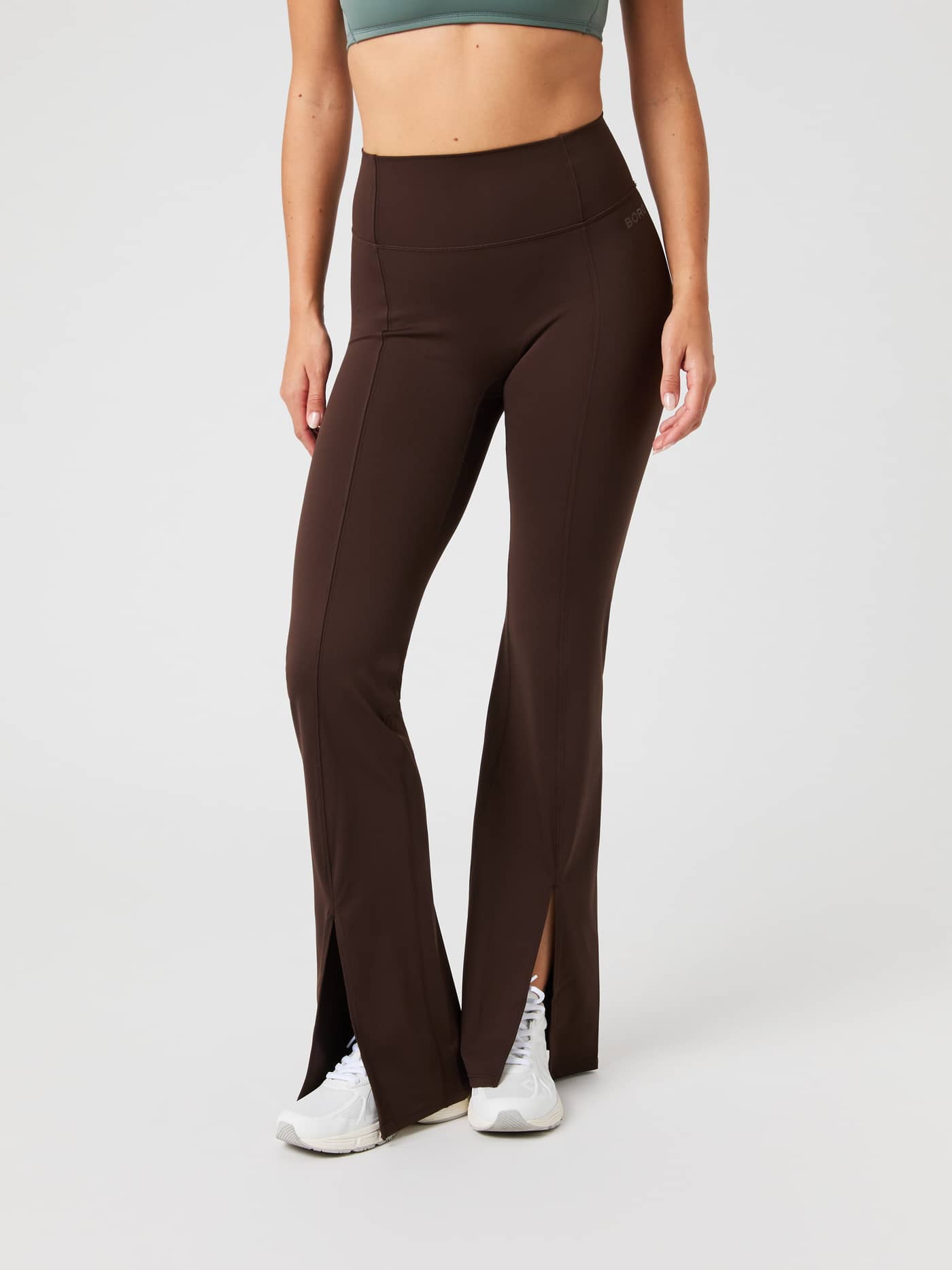 Front view of a model wearing the Björn Borg Studio Flared Slit Tights in Molé (Brown) with a flared fit for training. - Image 1