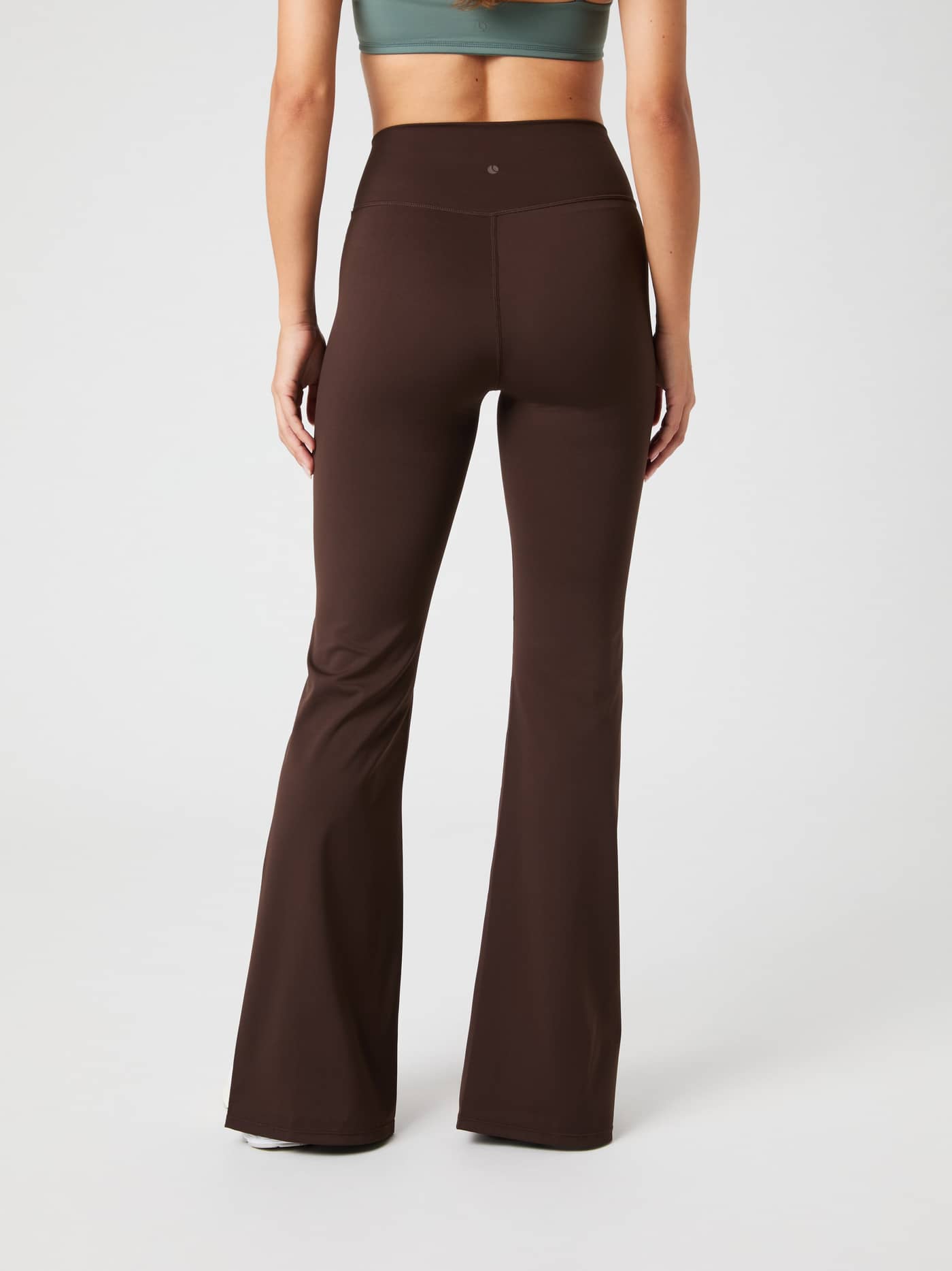 Back view of a model wearing Björn Borg Studio Flared Slit Tights in Molé (Brown), featuring a stylish fit for training. - Image 3