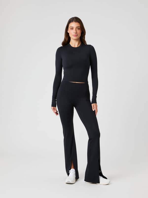 Studio Flared Slit Tights i Black Beauty (Svart) för dam sedda i helfigur framifrån för en modern träningslook.