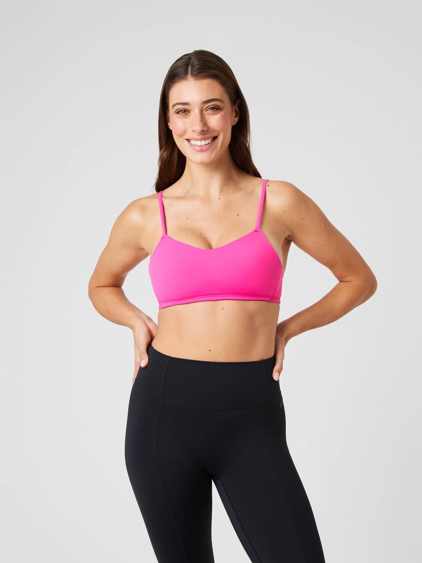 Front view of a model wearing the Björn Borg Studio Soft Padded Bra in Pink, featuring a tonal logo and stylish training fit. - Image 5