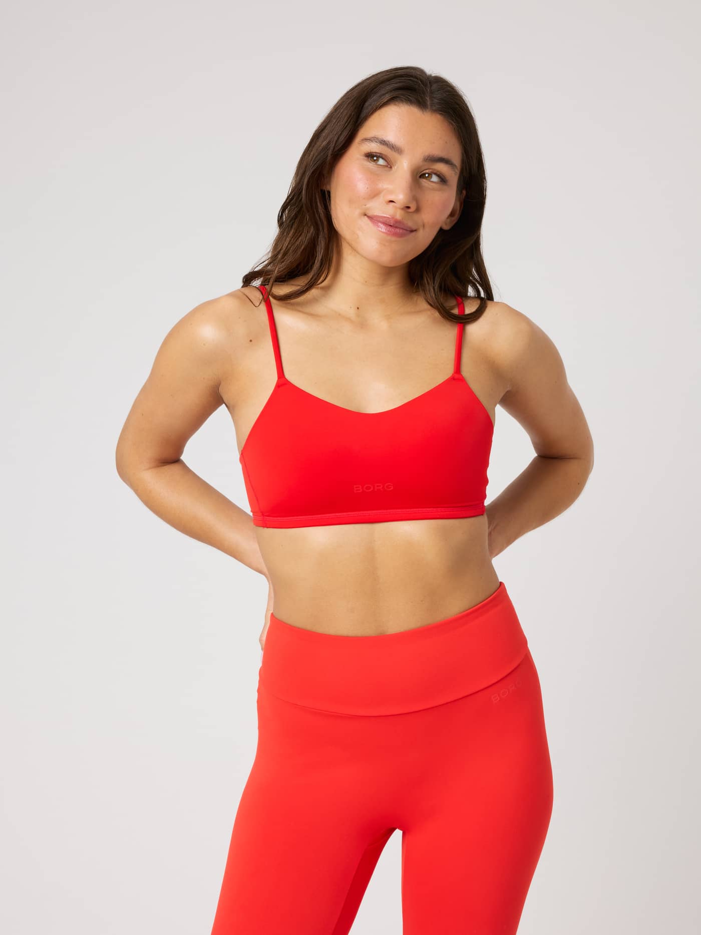 Front view of a model wearing the Björn Borg Studio Soft Padded Bra in Flame Scarlet (Red) for training with a red logo. - Image 2