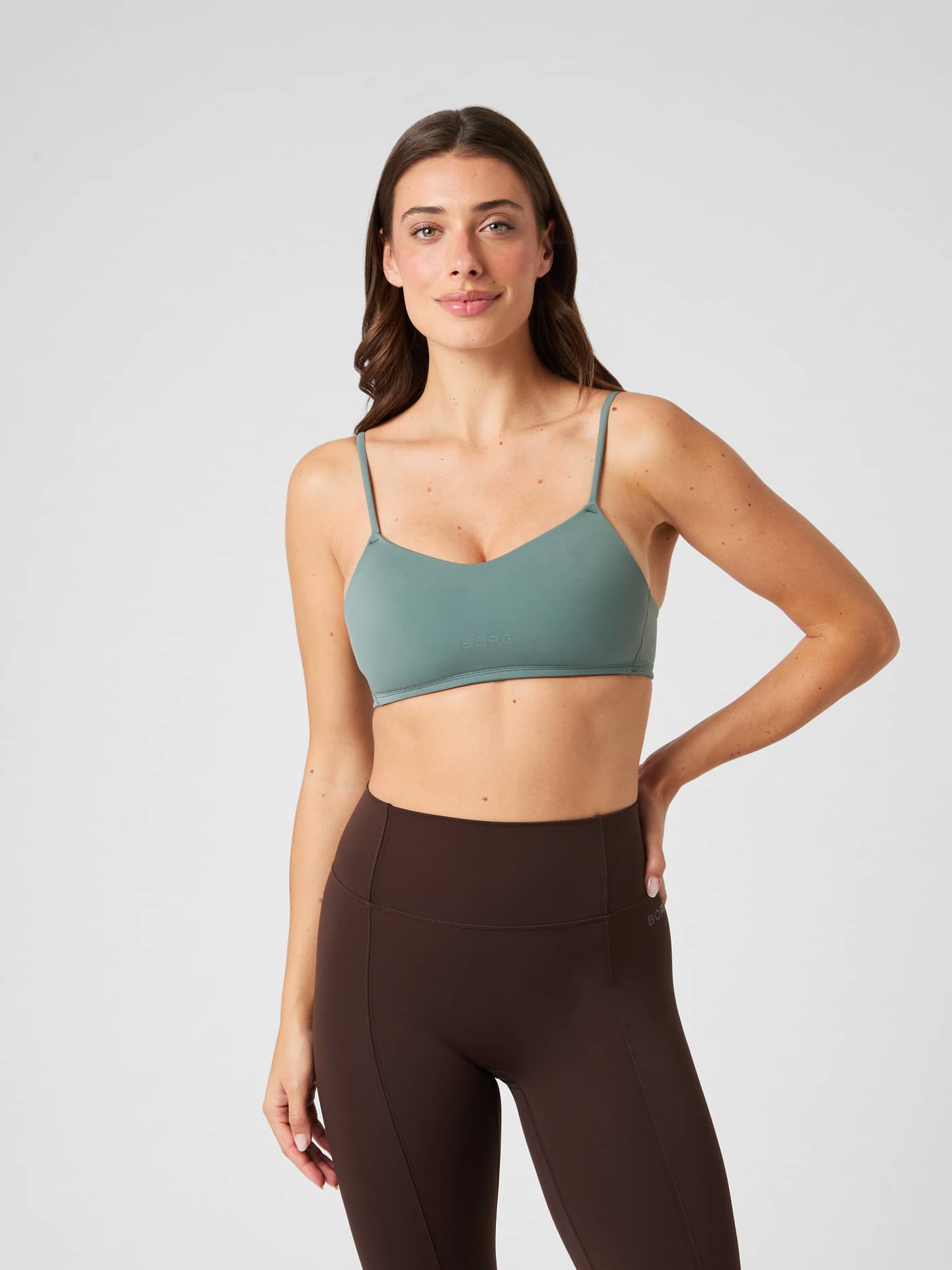 Front view of a model wearing the Green Studio Soft Padded Bra with a green logo, designed for a supportive training fit. - Image 7