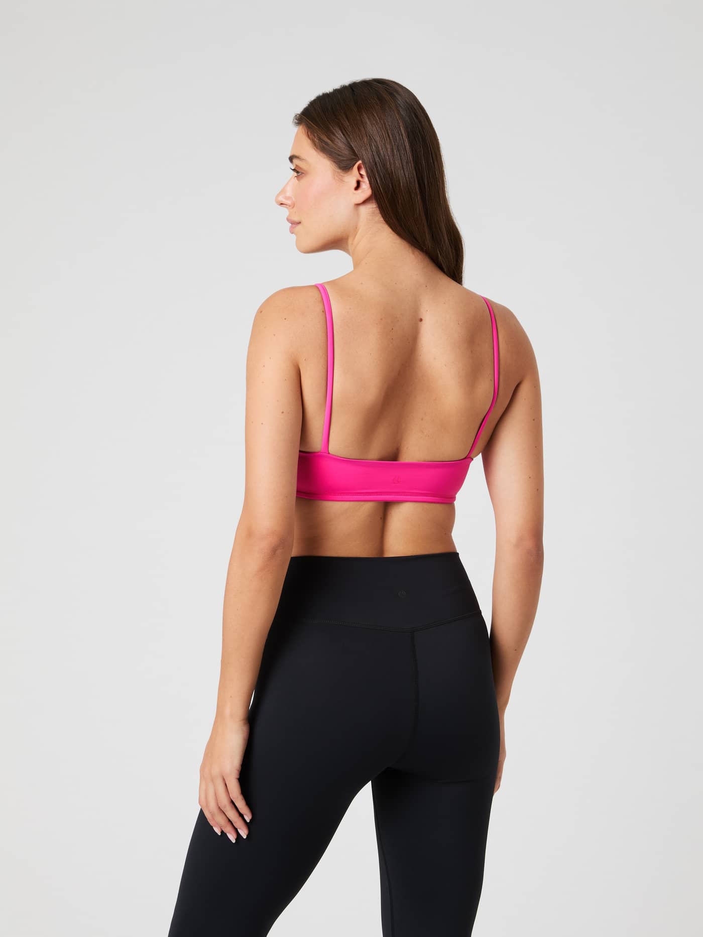 Back view of a model wearing the pink Björn Borg Studio Soft Padded Bra, a stylish training top with a performance fit. - Image 2