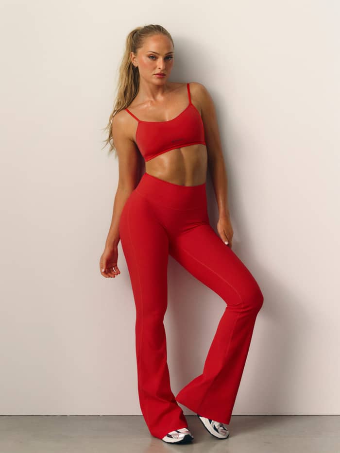 Vooraanzicht van een model dat de Studio Soft Padded Bra draagt in Flame Scarlet (rood) voor training. - Image 1