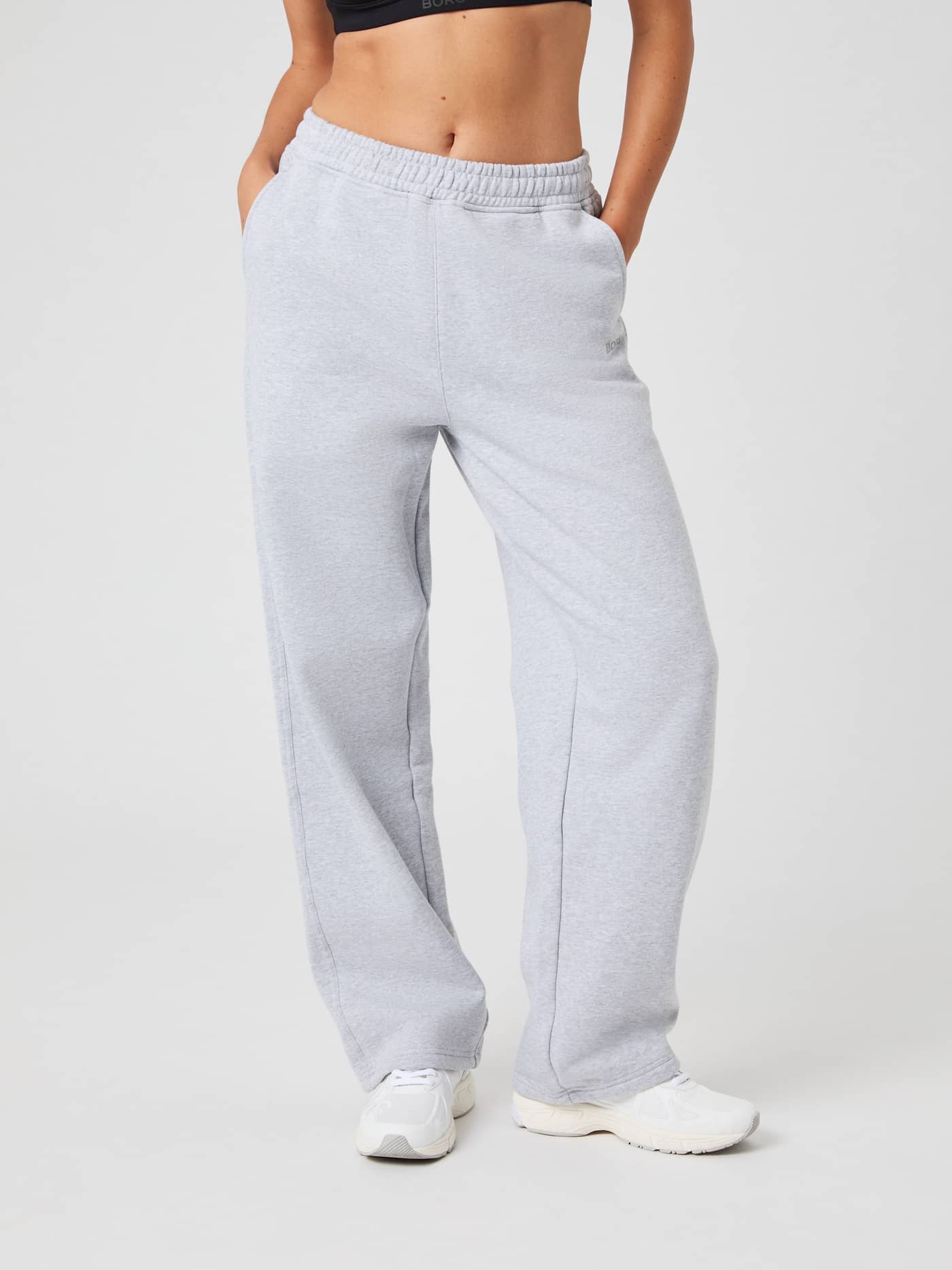 Front view of a model wearing the Studio Oversized Straight Sweatpants in a light grey melange color. - Image 1