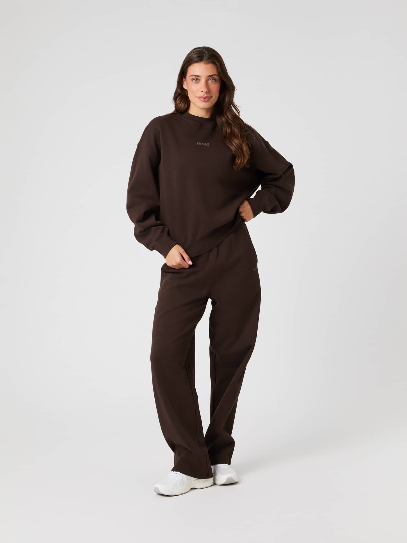 Model wears the brown Studio Oversized Straight Sweatpants with a matching sweatshirt in a full-length studio shot. - Image 3