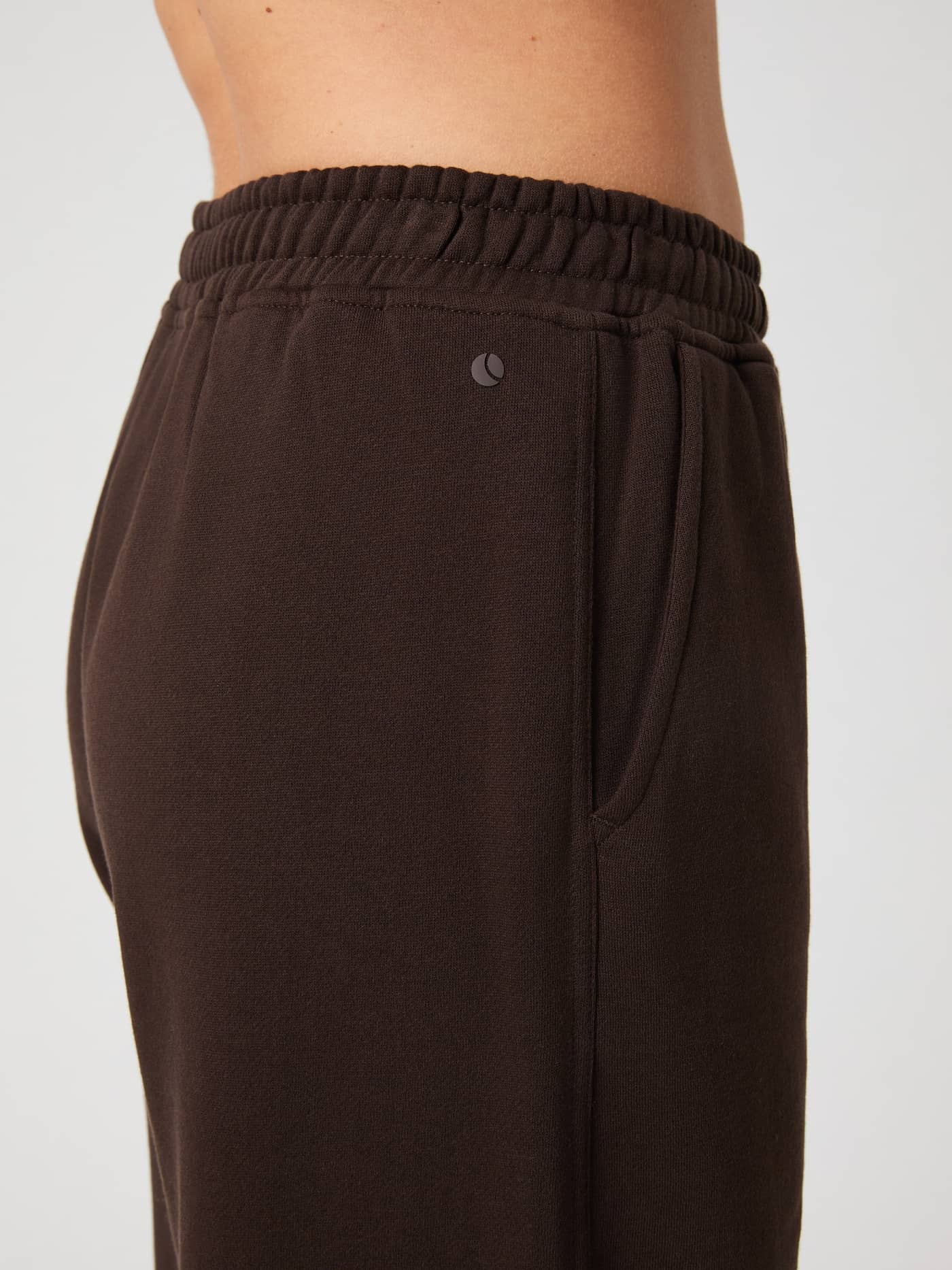 Side close-up of the Björn Borg Studio Oversized Straight Sweatpants in Molé brown, showing the elastic waistband and logo. - Image 5