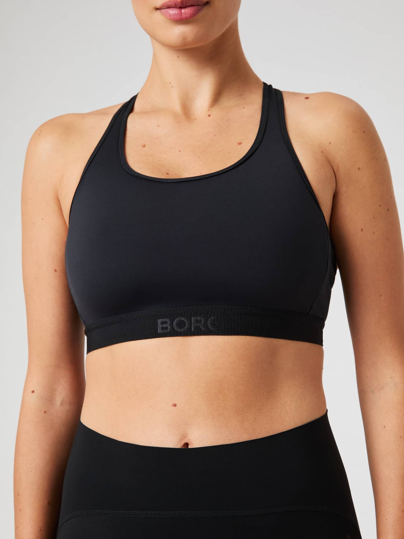 Vue de face de la Borg Low Support Sports Bra en Black Beauty (Noir) avec logo en relief et coupe pour l'entraînement. - Image 4