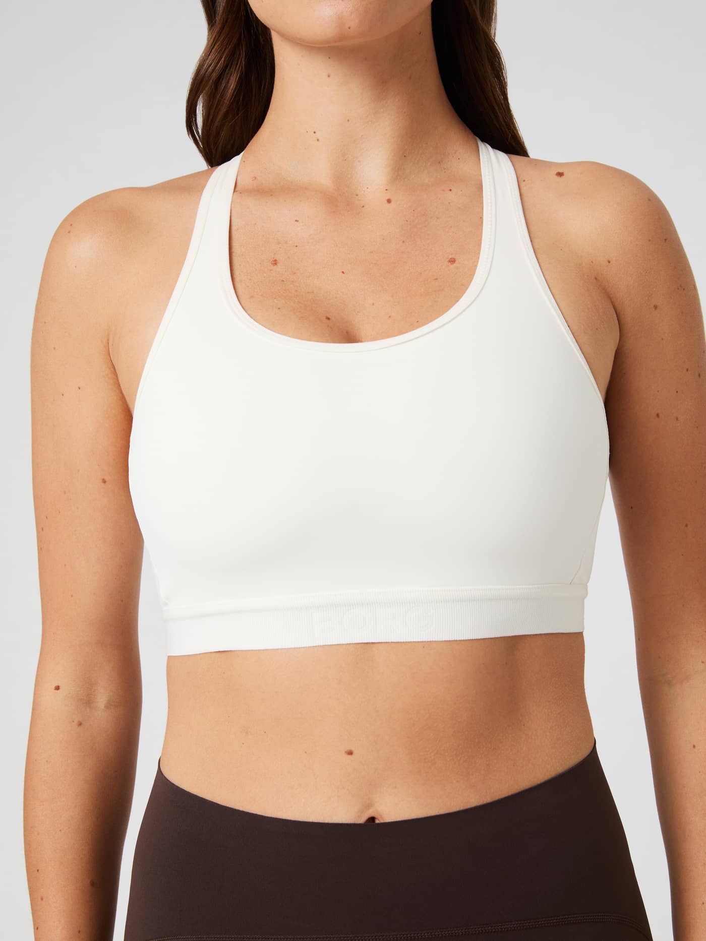 Front view of a model wearing the white Borg Low Support Sports Bra, featuring a stylish fit for training sessions. - Image 4