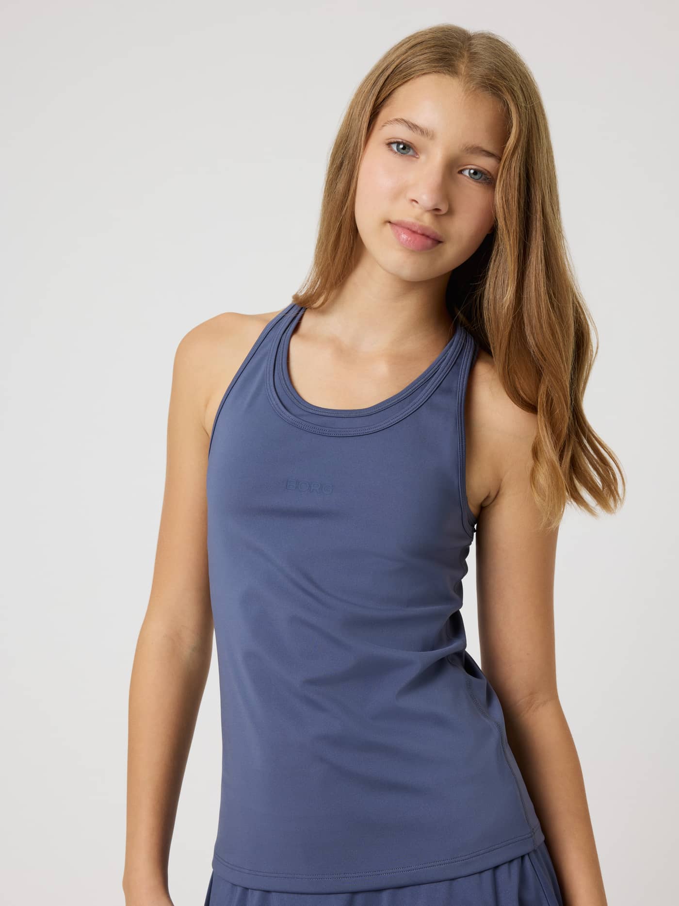 Front view of a girl in the Borg Racerback Tank Top in Nightshadow Blue (Blue) with a tonal logo for kids' training. - Image 3