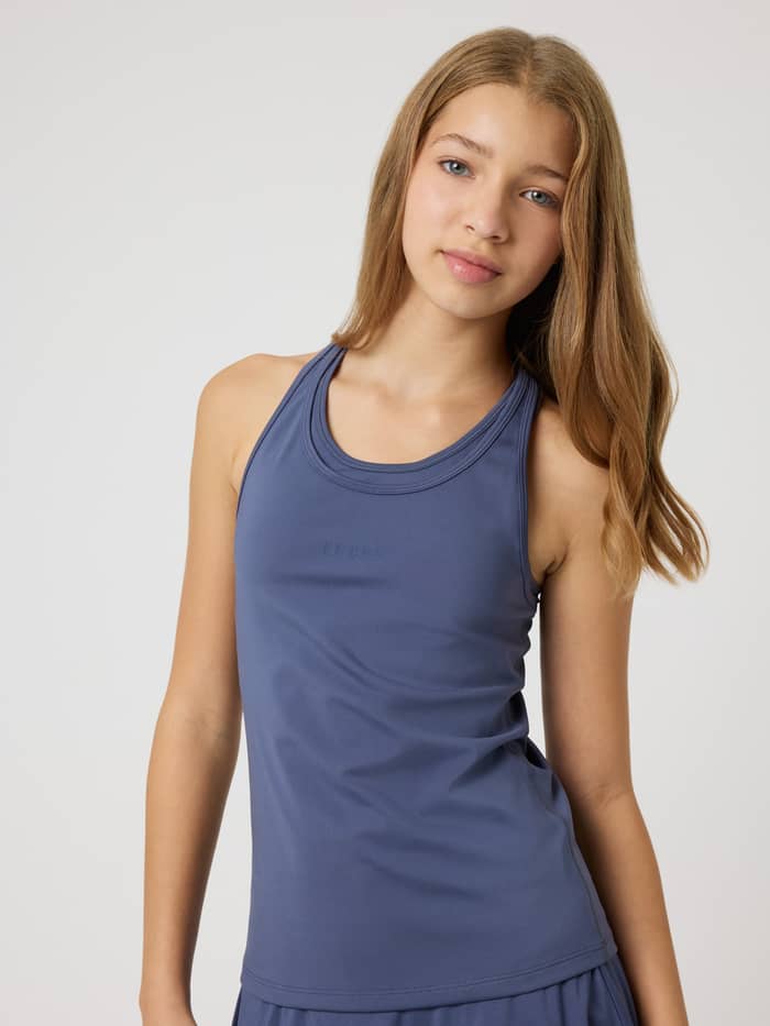 Vorderansicht eines Mädchens im Borg Racerback Tank Top in Nightshadow Blue (Blau) mit tonalem Logo für das Kids-Training. - Image 3
