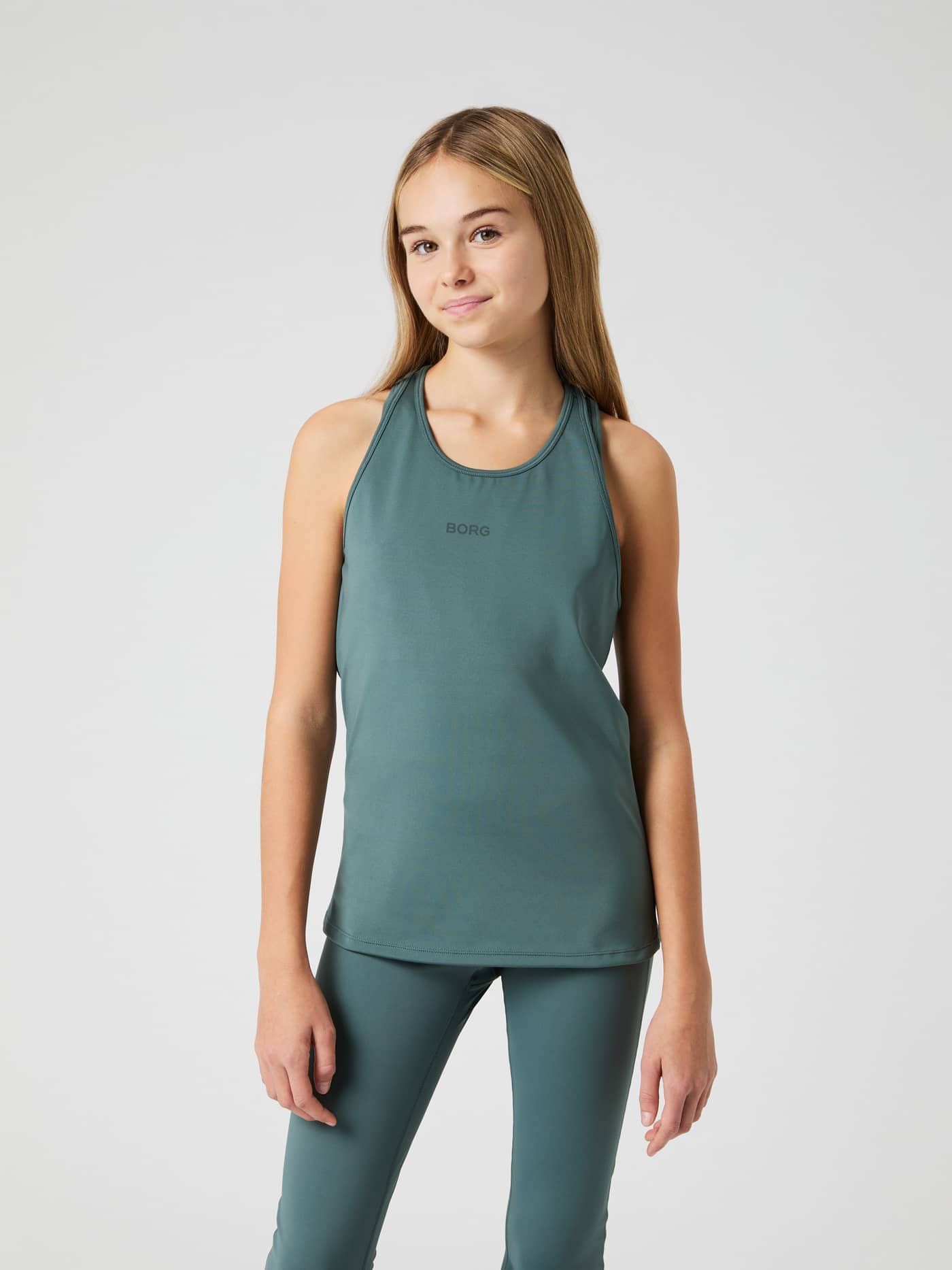 Front view of a kid in the Balsam Green (Green) Borg Racerback Tank Top, a training essential with a supportive fit. - Image 1