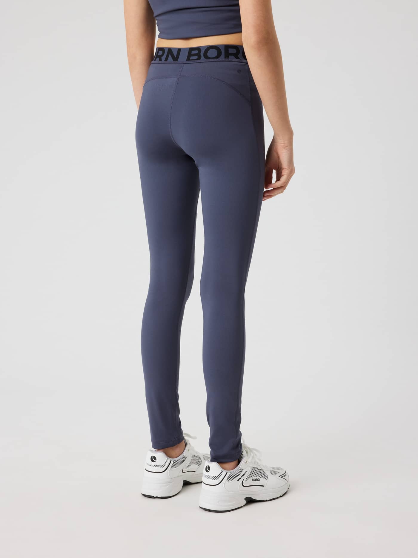 Back view of a kid wearing the kids' Borg Leggings in Odyssey Gray (Navy) with a black logo waistband for training. - Image 3