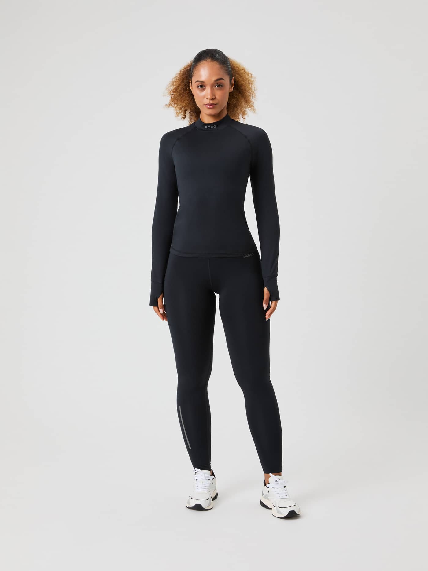 Full-body front view of a woman in the running Borg Performance Brushed Mockneck in Black Beauty (Black) with a grey logo. - Image 3