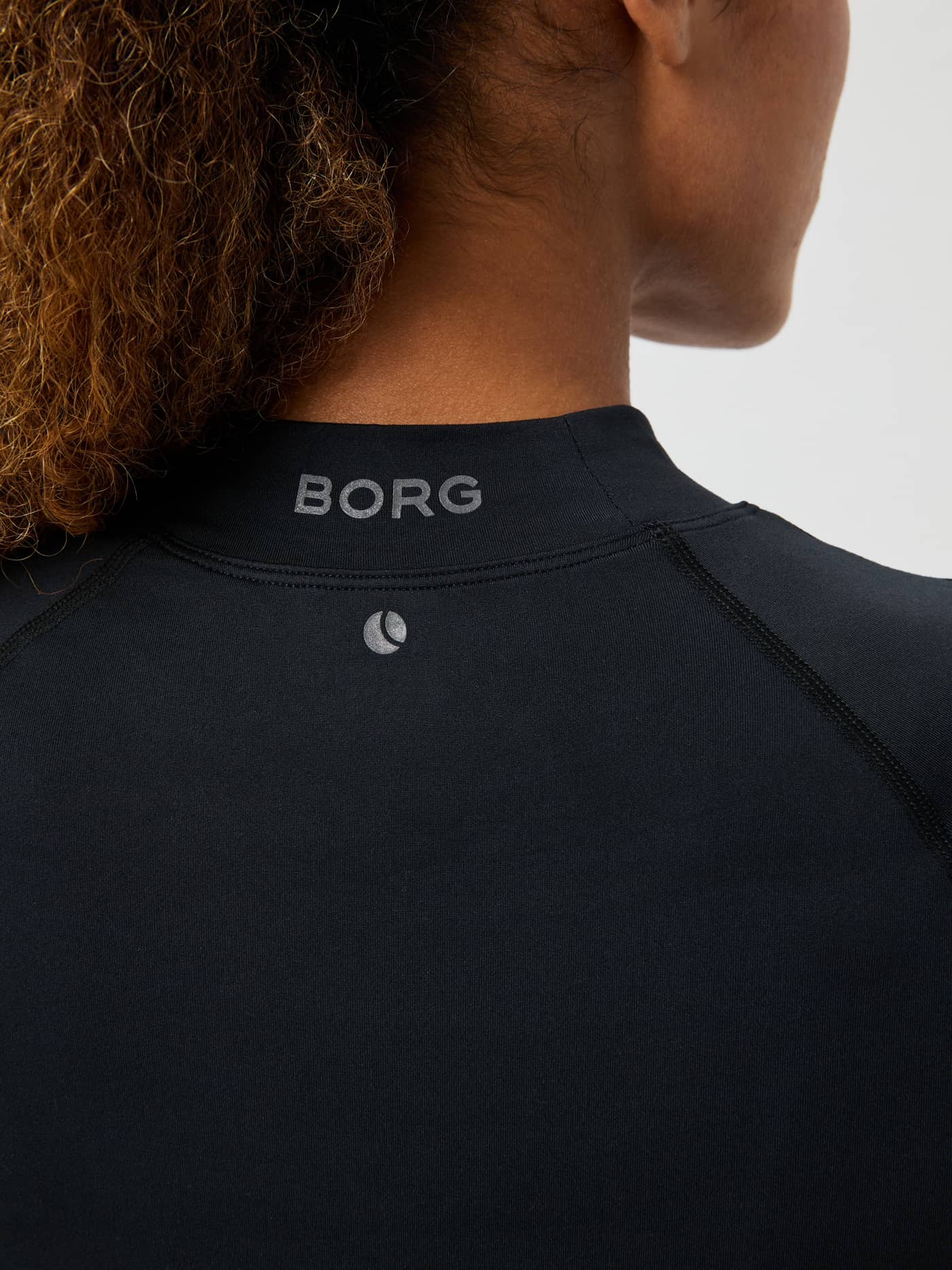 Close-up back view of the Borg Performance Brushed Mockneck in Black Beauty (Black) featuring a grey logo for running. - Image 5